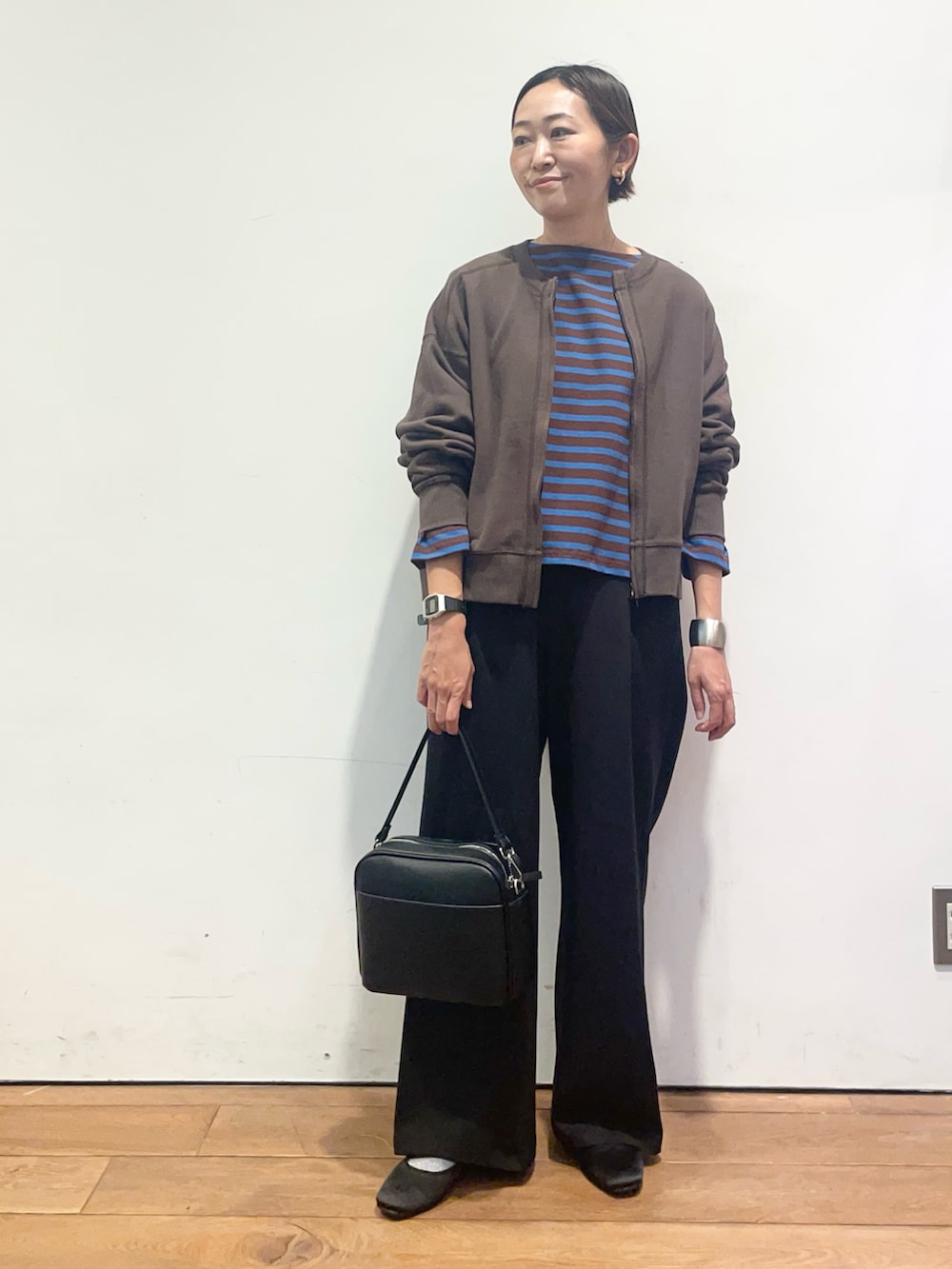 ブラウン系のカーディガン/ボレロ、ブラウン系のTシャツ/カットソー、ブラック系のその他パンツを着用したレディースの秋コーディネートの4枚目の写真