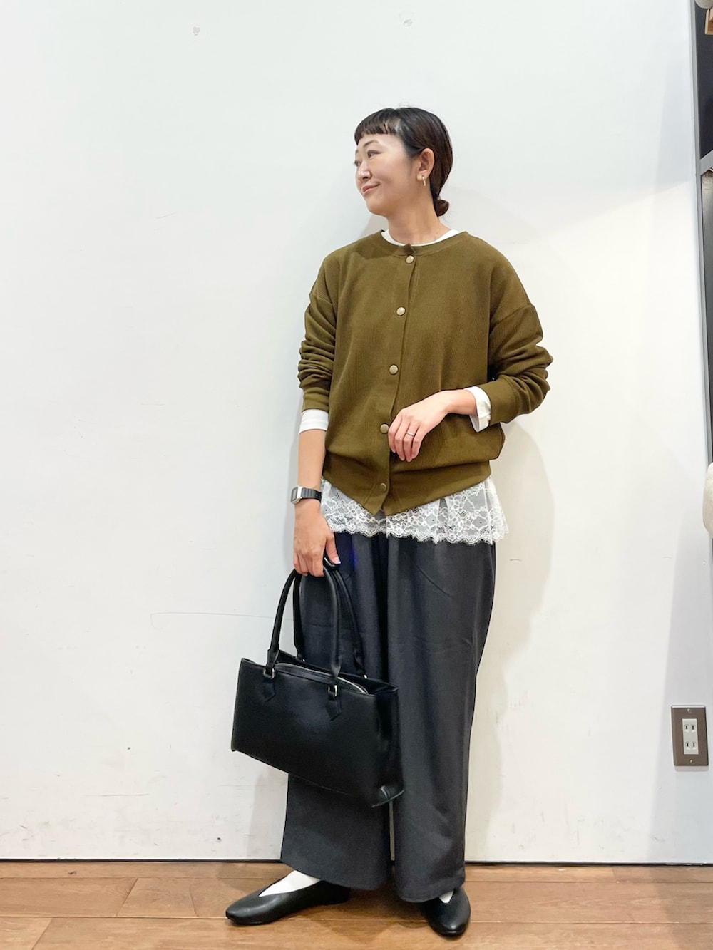 ブラウン系のカーディガン/ボレロ、ホワイト系のTシャツ/カットソー、ブラック系のハンドバッグを着用したレディースの秋コーディネートの2枚目の写真