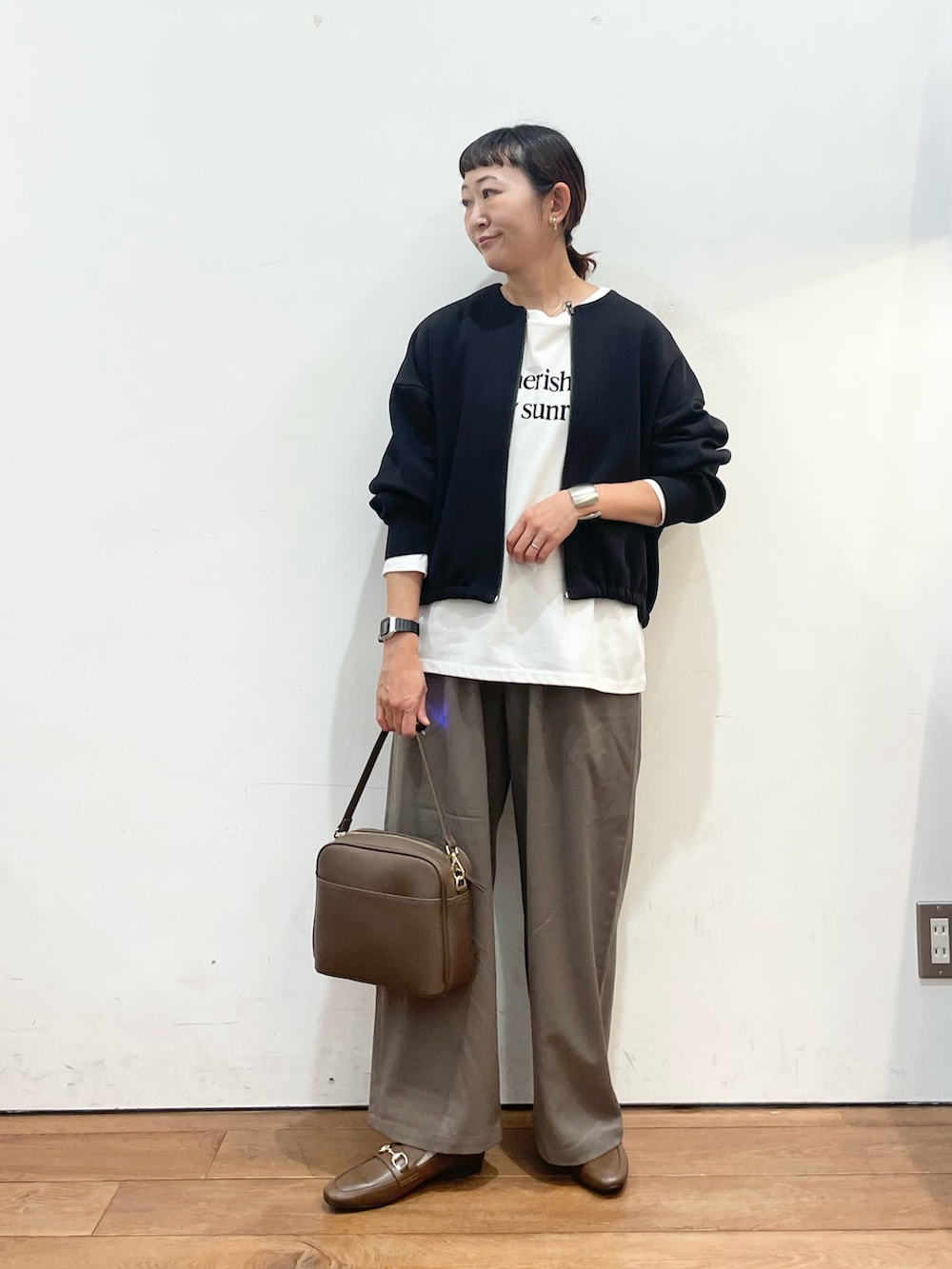 ブラック系のカーディガン/ボレロ、ホワイト系のTシャツ/カットソー、ベージュ系のその他パンツを着用したレディースの秋コーディネートの3枚目の写真