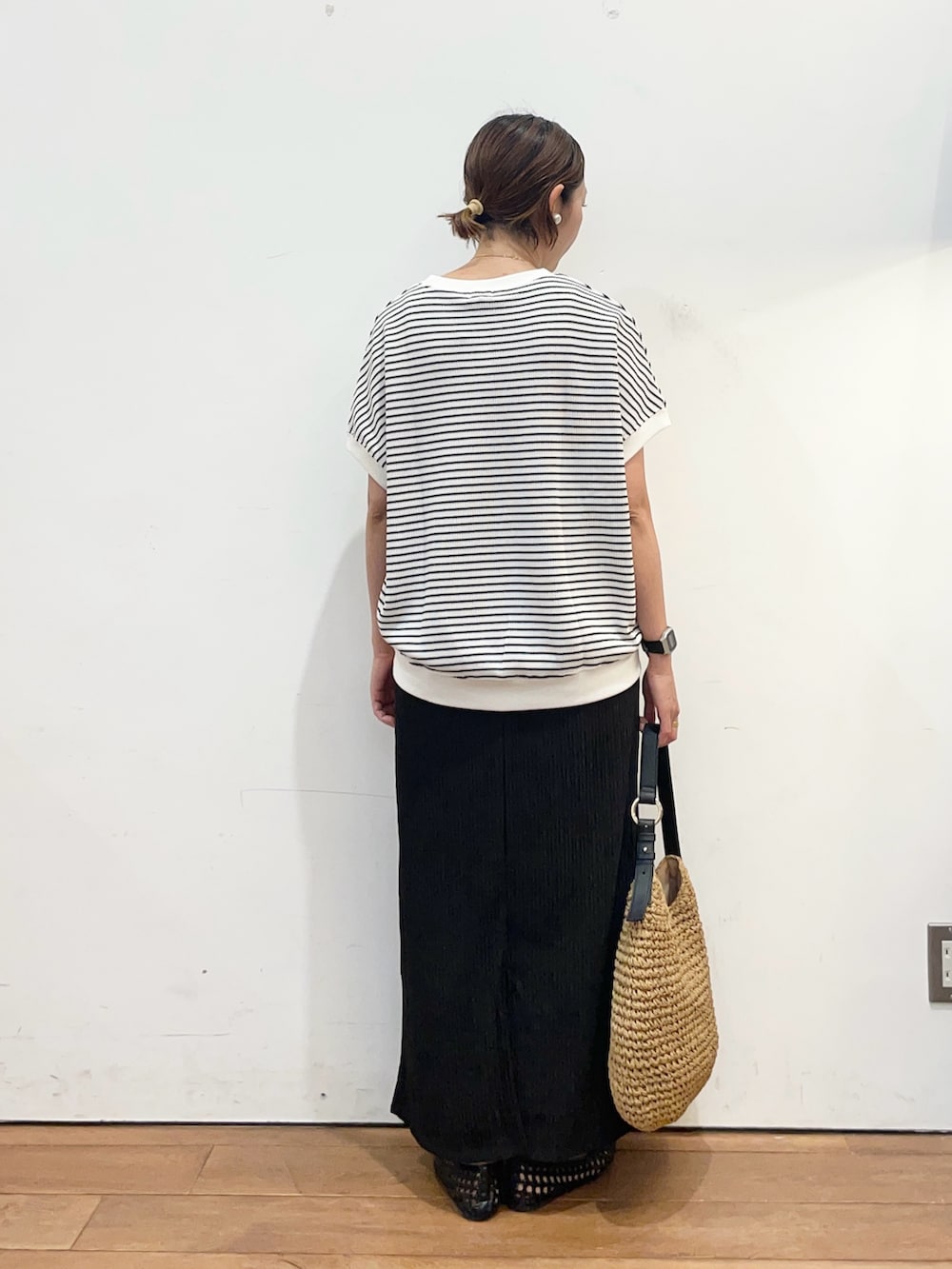 ブラック系のサンダル、イエロー系のトートバッグ、ホワイト系のTシャツ/カットソーを着用したレディースの春コーディネートの4枚目の写真