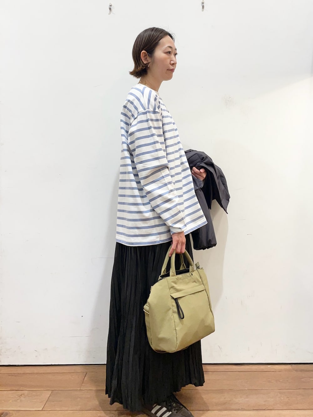 グレー系のブルゾン、ブラック系のスカート、ブルー系のTシャツ/カットソーを着用したレディースの冬コーディネートの6枚目の写真