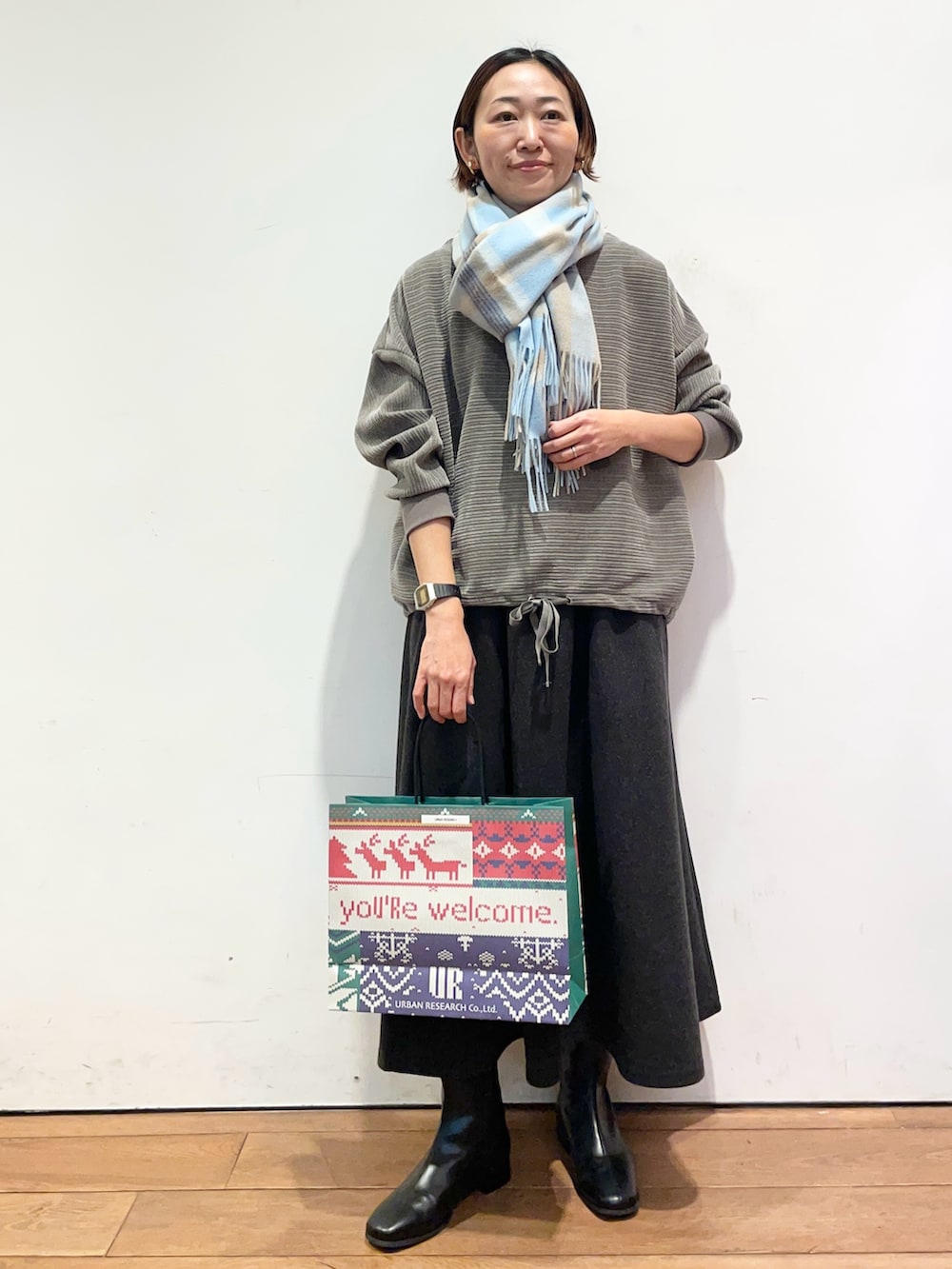 グレー系のスカート、ブラック系のブーツ、グレー系のTシャツ/カットソーを着用したレディースの冬コーディネートの3枚目の写真