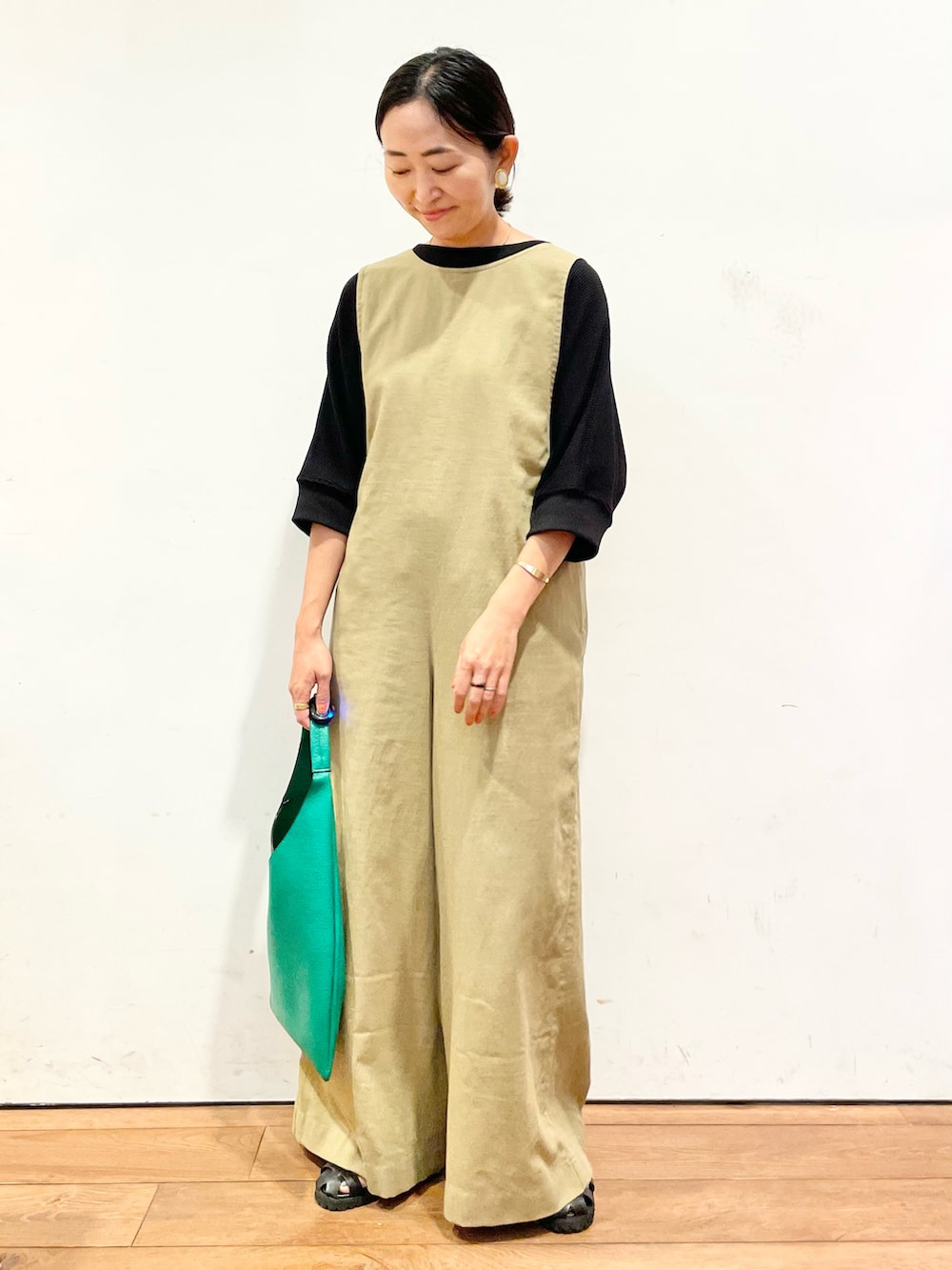 ブラック系のTシャツ/カットソー、ベージュ系のサロペット/オーバーオール、グリーン系のトートバッグを着用したレディースの夏コーディネートの3枚目の写真