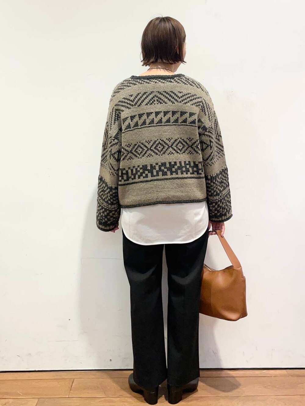 ブラック系のブーツ、イエロー系のショルダーバッグ、ホワイト系のTシャツ/カットソーを着用したレディースの冬コーディネートの5枚目の写真