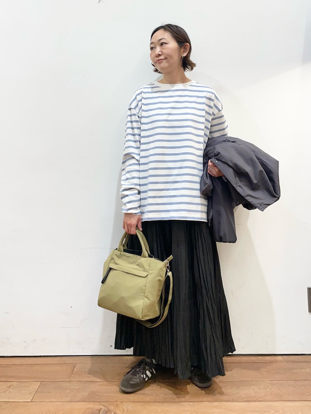 グレー系のブルゾン、ブラック系のスカート、ブルー系のTシャツ/カットソーを着用したレディースの冬コーディネートの5枚目の写真