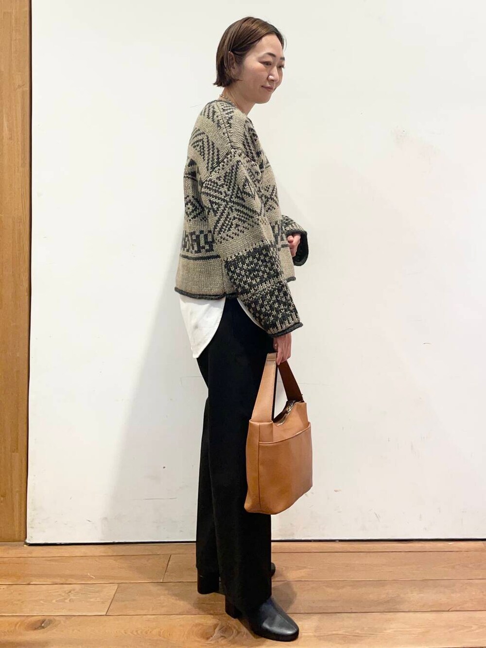 ブラック系のブーツ、イエロー系のショルダーバッグ、ホワイト系のTシャツ/カットソーを着用したレディースの冬コーディネートの4枚目の写真