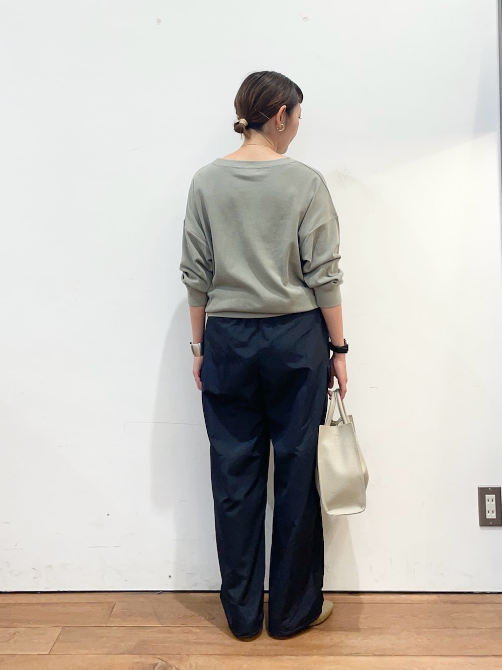 グリーン系のTシャツ/カットソー、グレー系のハンドバッグ、ブラウン系のスリッポンを着用したレディースの秋コーディネートの4枚目の写真