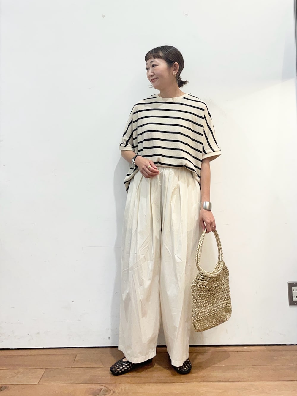 ホワイト系のTシャツ/カットソー、ホワイト系のその他パンツ、ゴールド系のトートバッグを着用したレディースの夏コーディネートの2枚目の写真