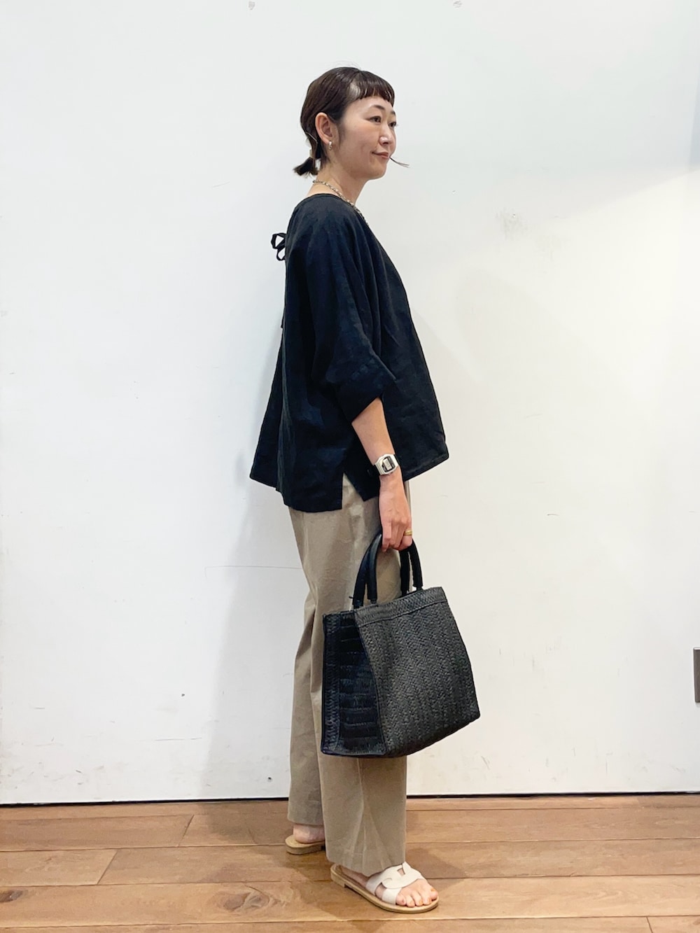 ブラック系のシャツ/ブラウス、ベージュ系のその他パンツ、ブラック系のハンドバッグを着用したレディースの夏コーディネートの3枚目の写真