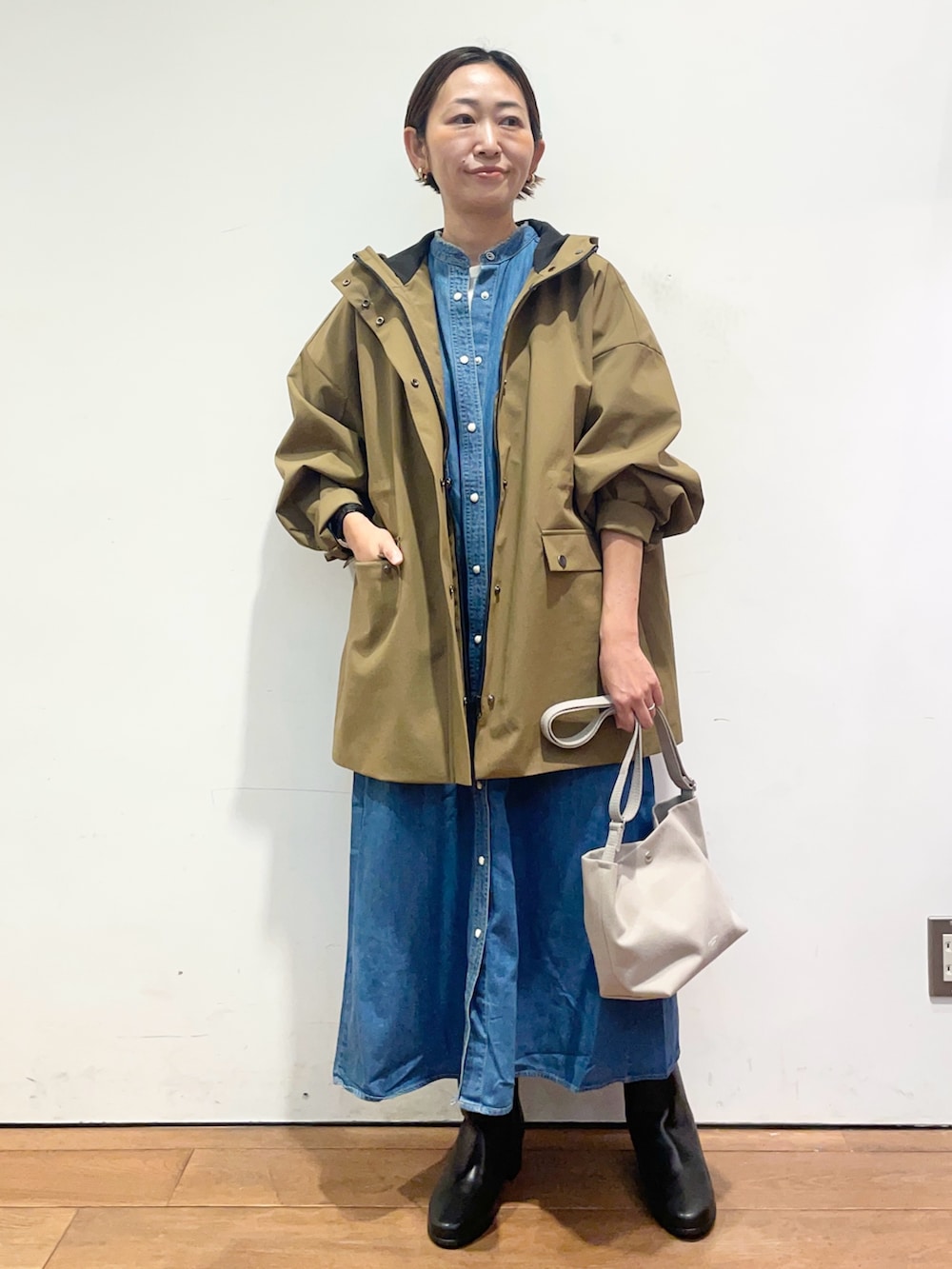 ベージュ系のその他アウター、ブルー系のワンピース、ブラック系のブーツを着用したレディースの秋コーディネートの2枚目の写真