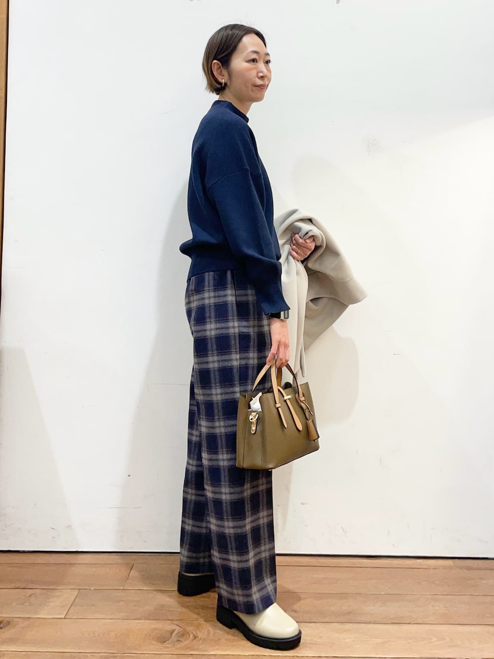 ベージュ系のその他アウター、ブルー系のニット/セーター、ブラウン系のハンドバッグを着用したレディースの冬コーディネートの7枚目の写真