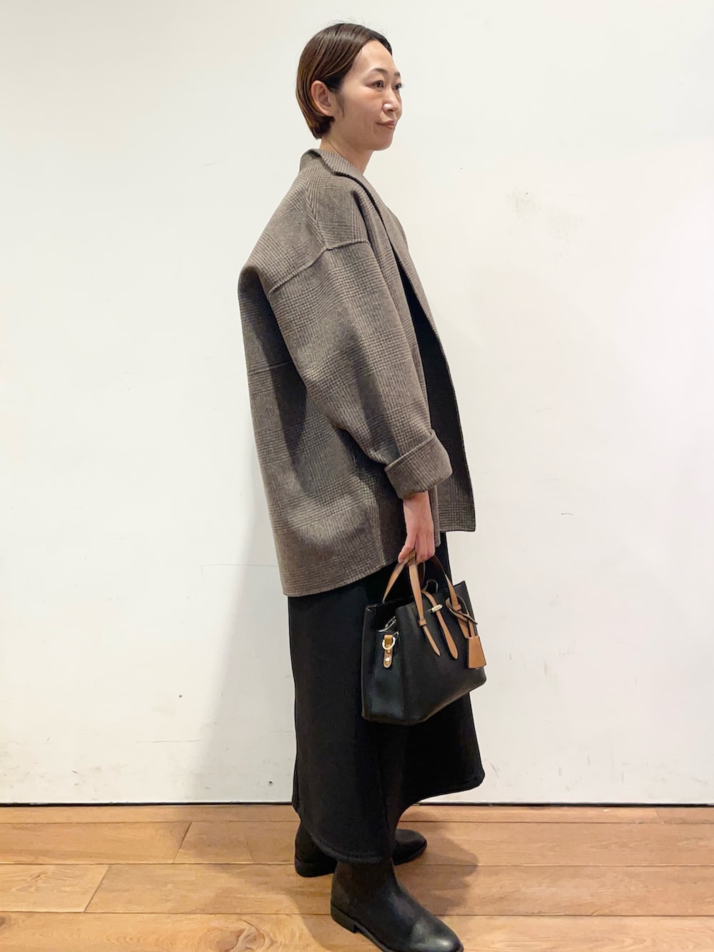 ブラック系のブーツ、ブラック系のハンドバッグ、その他のその他アウターを着用したレディースの秋コーディネートの3枚目の写真