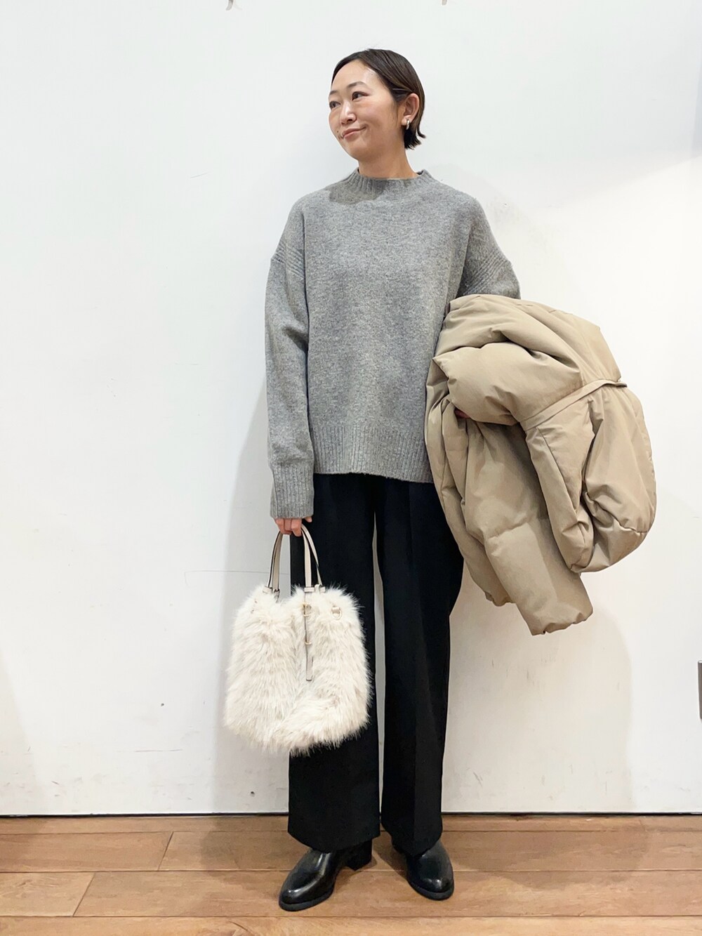 ブラウン系のダウンジャケット/コート、グレー系のニット/セーター、ブラック系のブーツを着用したレディースの冬コーディネートの5枚目の写真