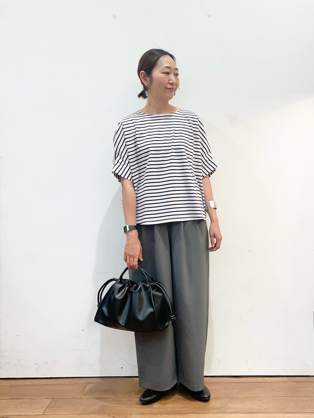 ホワイト系のTシャツ/カットソー、ブラック系のパンプス、ブラック系のトートバッグを着用したレディースの春コーディネートの3枚目の写真