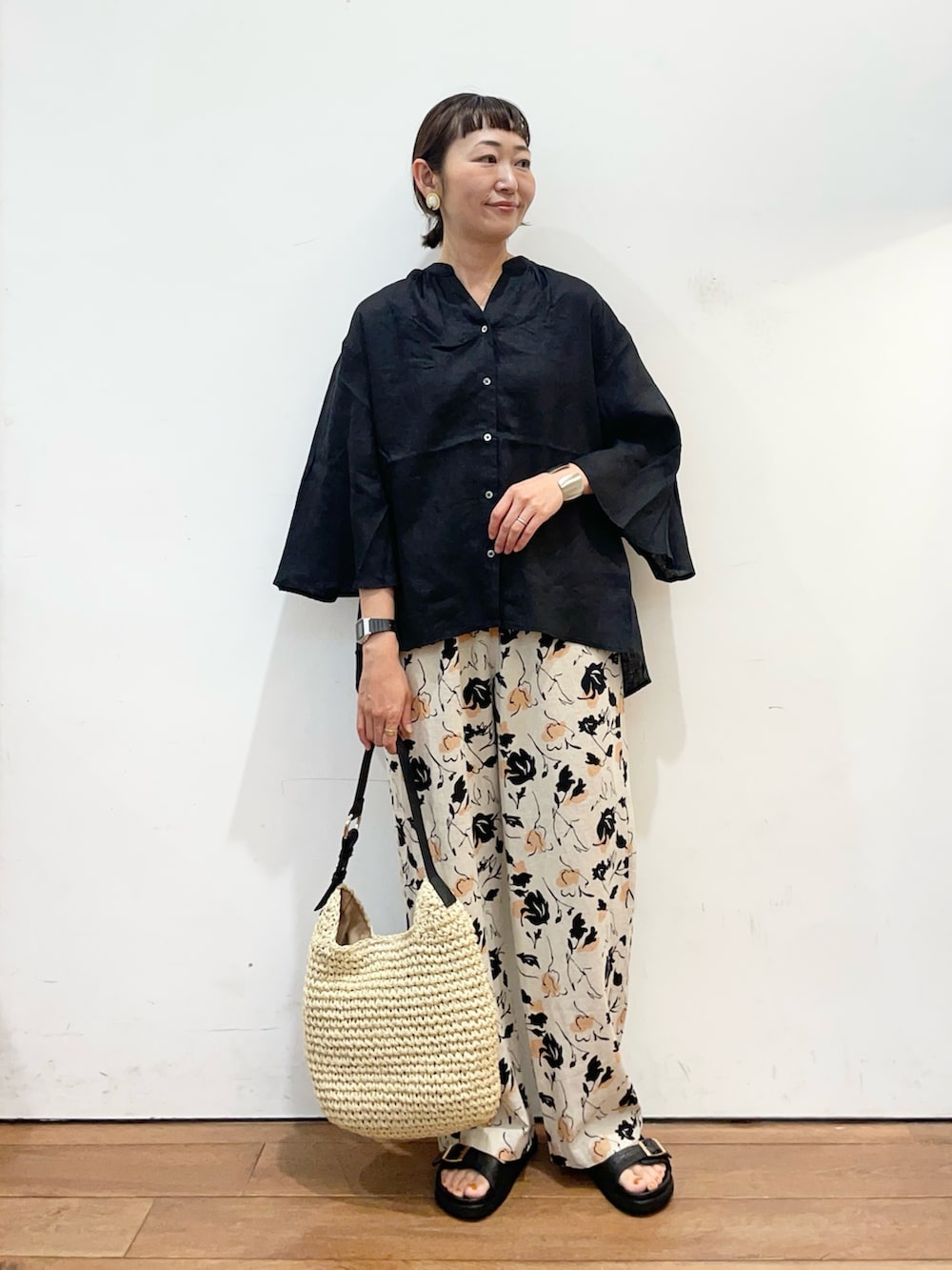 ブラック系のシャツ/ブラウス、ベージュ系のトートバッグ、ブラック系のサンダルを着用したレディースの夏コーディネートの2枚目の写真