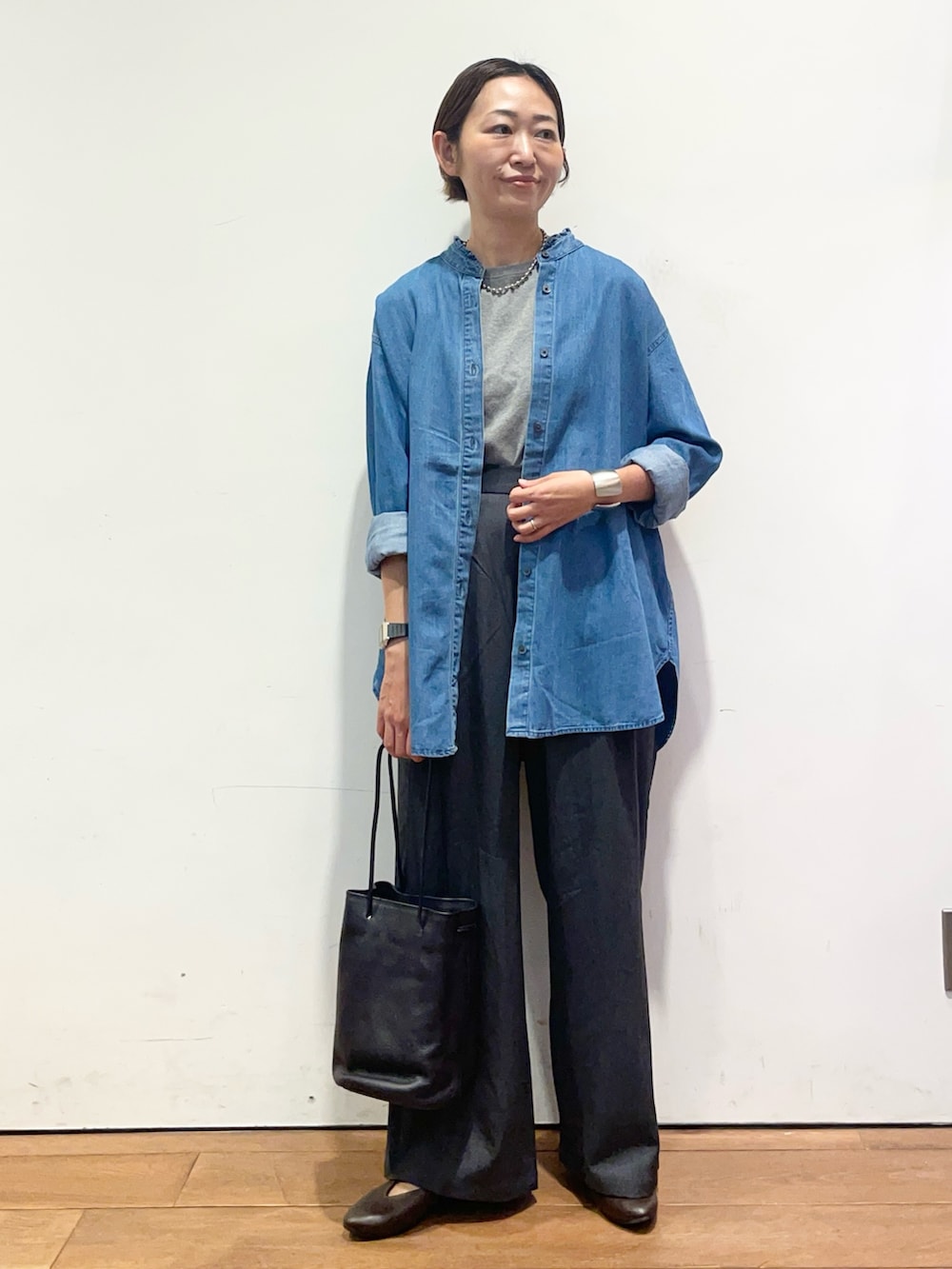 ブルー系のシャツ/ブラウス、ブラウン系のパンプス、グレー系のその他パンツを着用したレディースの秋コーディネートの3枚目の写真