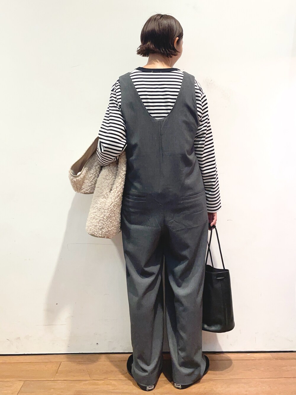 ブラック系のTシャツ/カットソー、ベージュ系のベスト、グレー系のサロペット/オーバーオールを着用したレディースの秋コーディネートの5枚目の写真