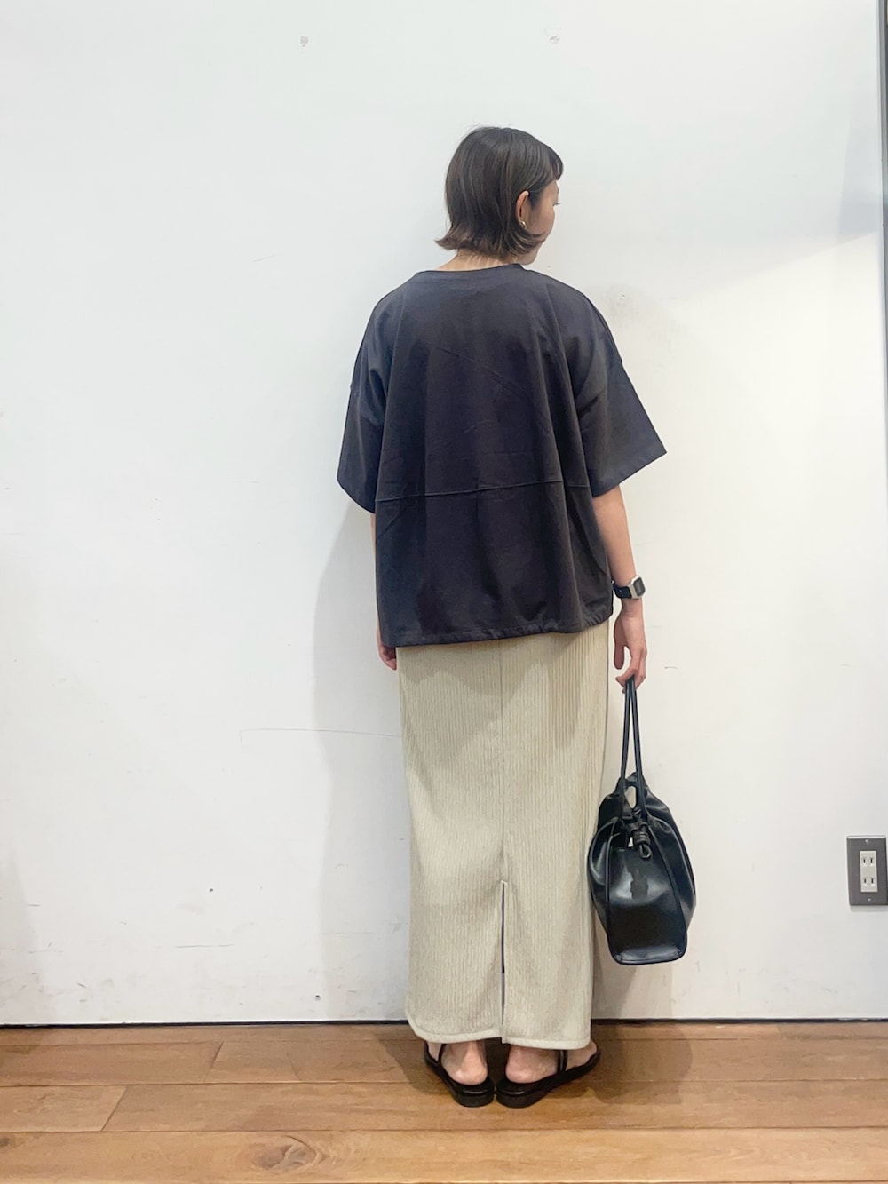 グレー系のTシャツ/カットソー、ベージュ系のスカート、ブラック系のトートバッグを着用したレディースの夏コーディネートの4枚目の写真