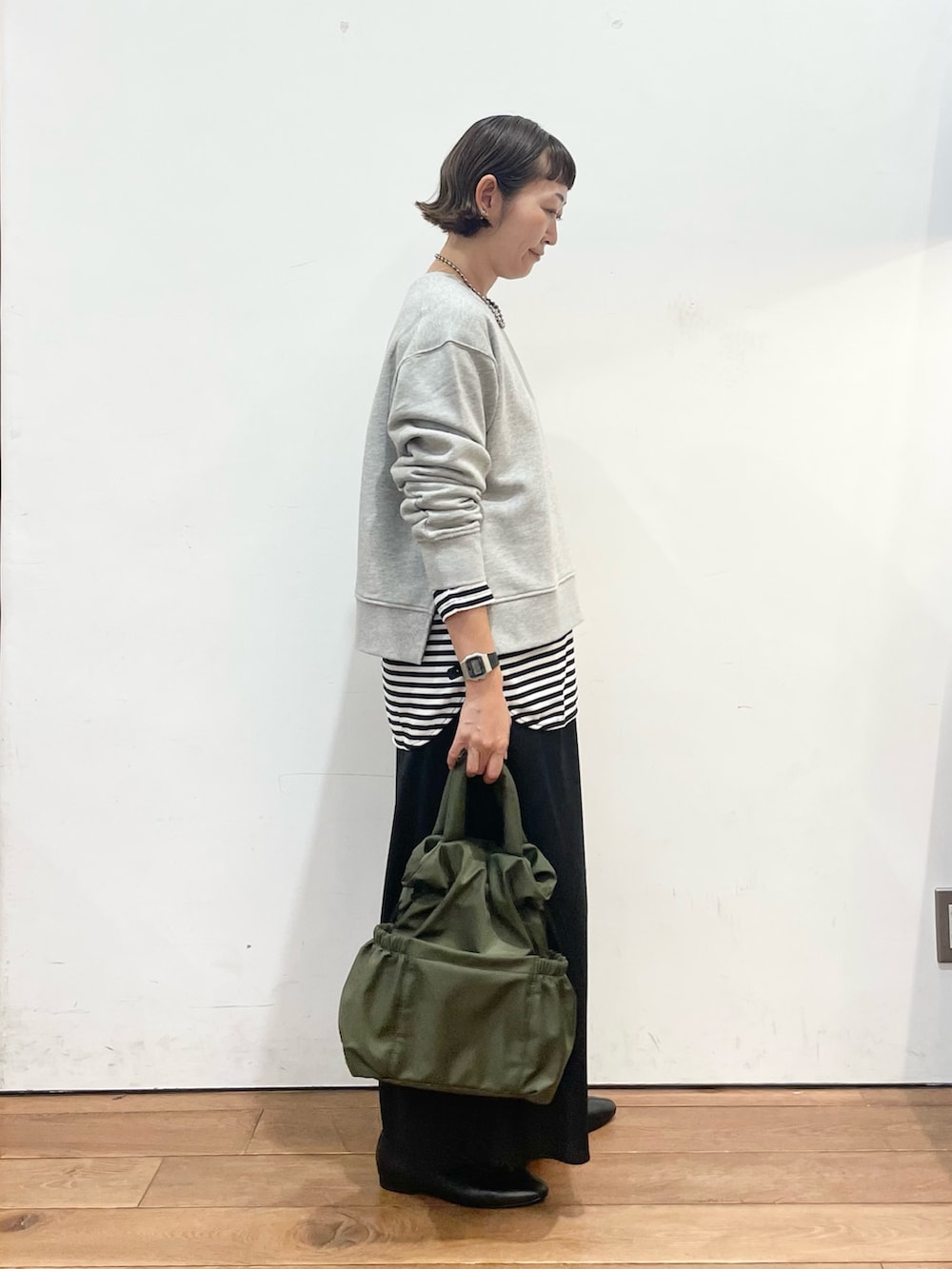 グレー系のスウェット、ホワイト系のTシャツ/カットソー、ブラック系のスリッポンを着用したレディースの秋コーディネートの4枚目の写真
