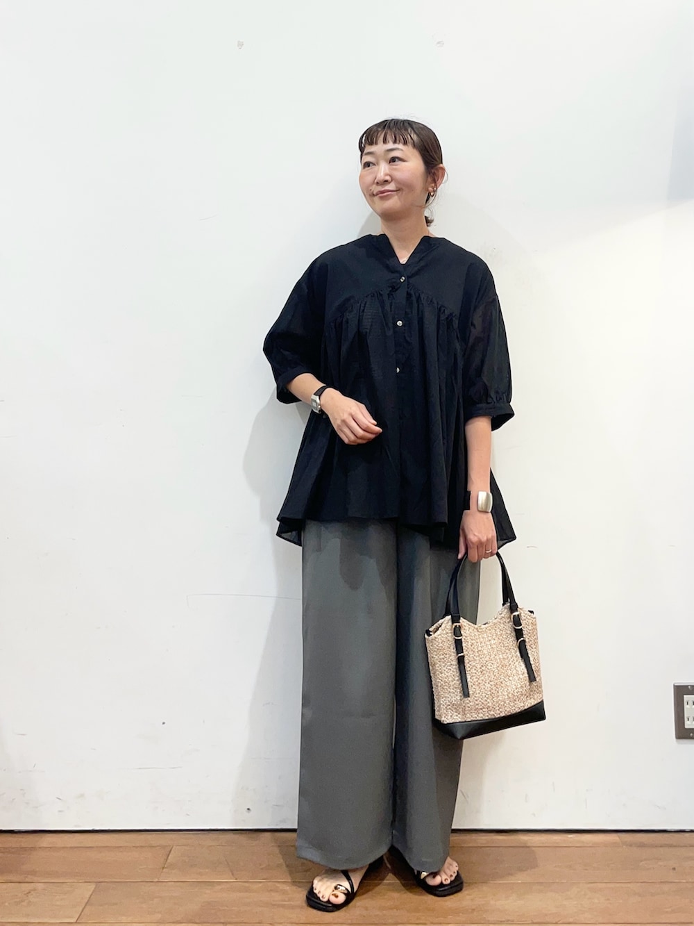ブラック系のシャツ/ブラウス、ブラック系のサンダル、ブラック系のショルダーバッグを着用したレディースの夏コーディネートの3枚目の写真