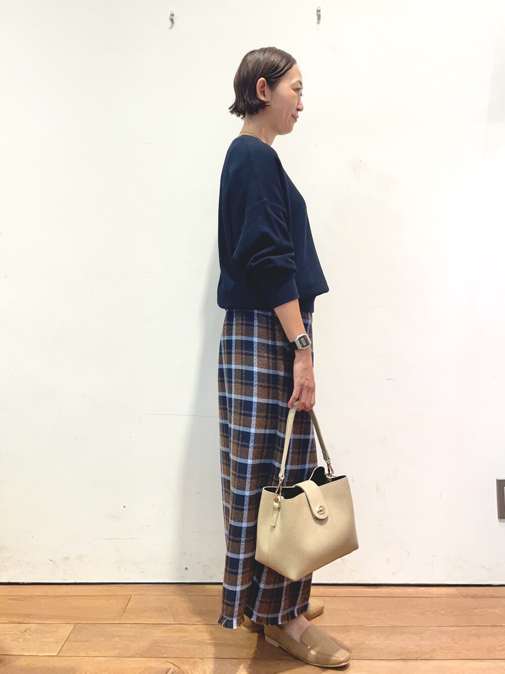 ブルー系のTシャツ/カットソー、ブラウン系のスカート、ベージュ系のローファーを着用したレディースの秋コーディネートの3枚目の写真