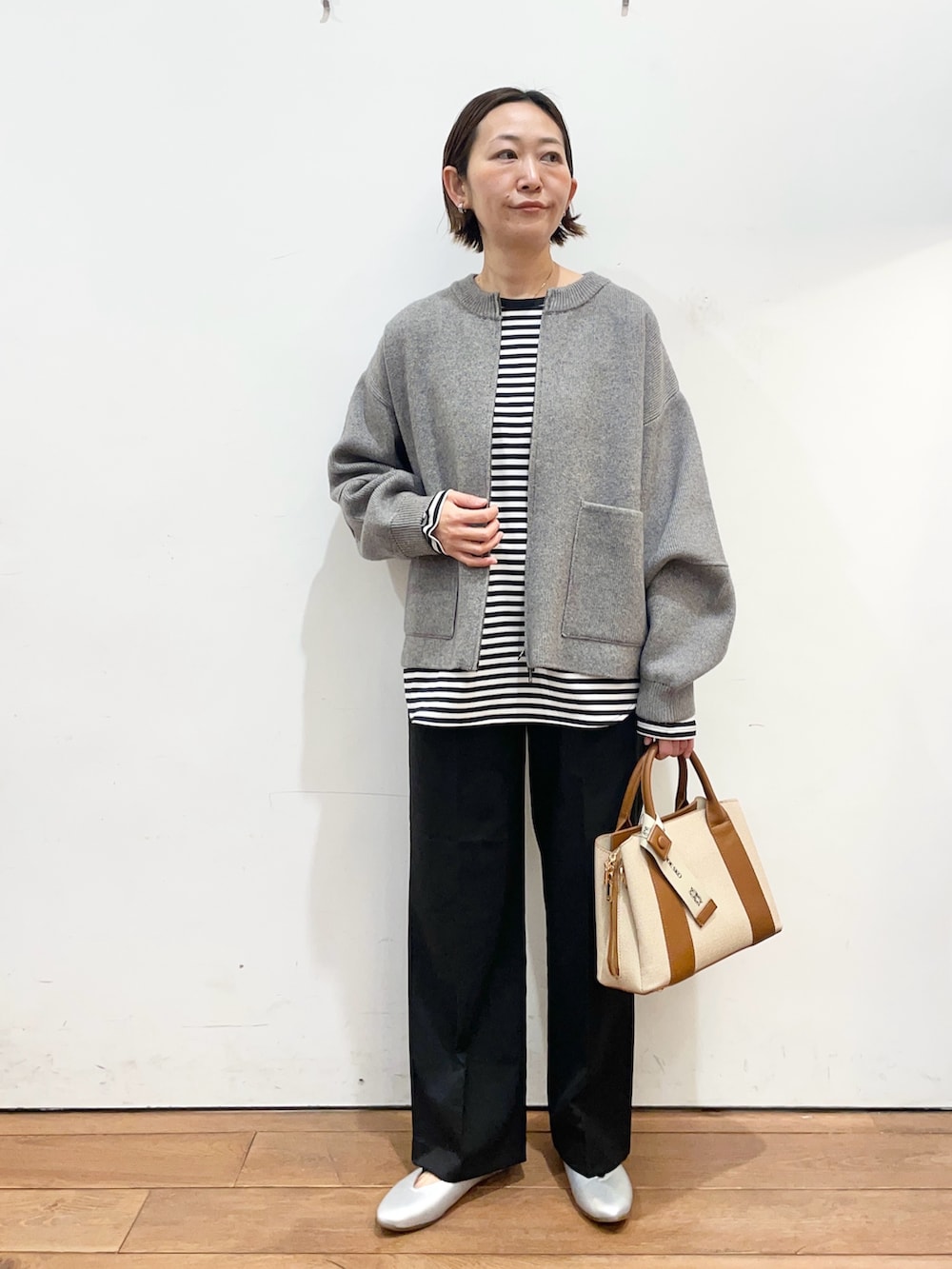 グレー系のブルゾン、ホワイト系のTシャツ/カットソー、ブラック系のその他パンツを着用したレディースの冬コーディネートの2枚目の写真