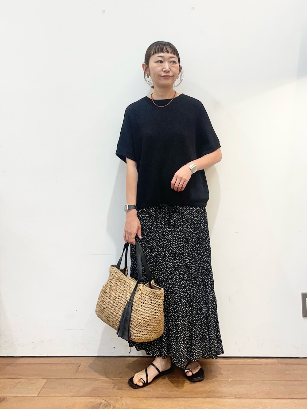 ブラック系のニット/セーター、ブラック系のスカート、ブラック系のサンダルを着用したレディースの夏コーディネートの2枚目の写真