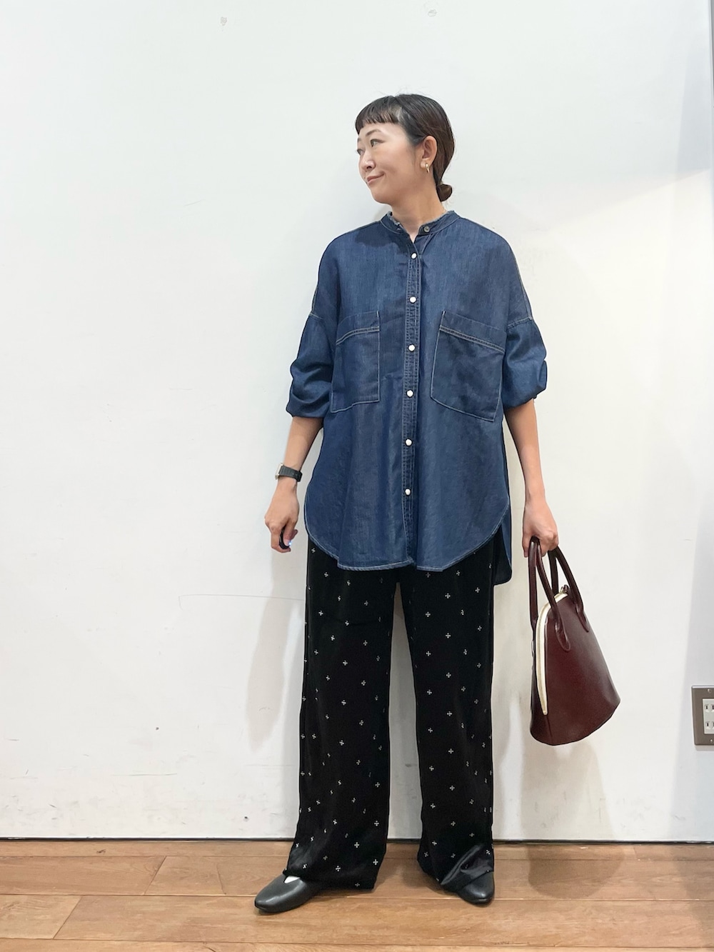 ブルー系のシャツ/ブラウス、レッド系のハンドバッグ、ブラック系のパンプスを着用したレディースの秋コーディネートの3枚目の写真