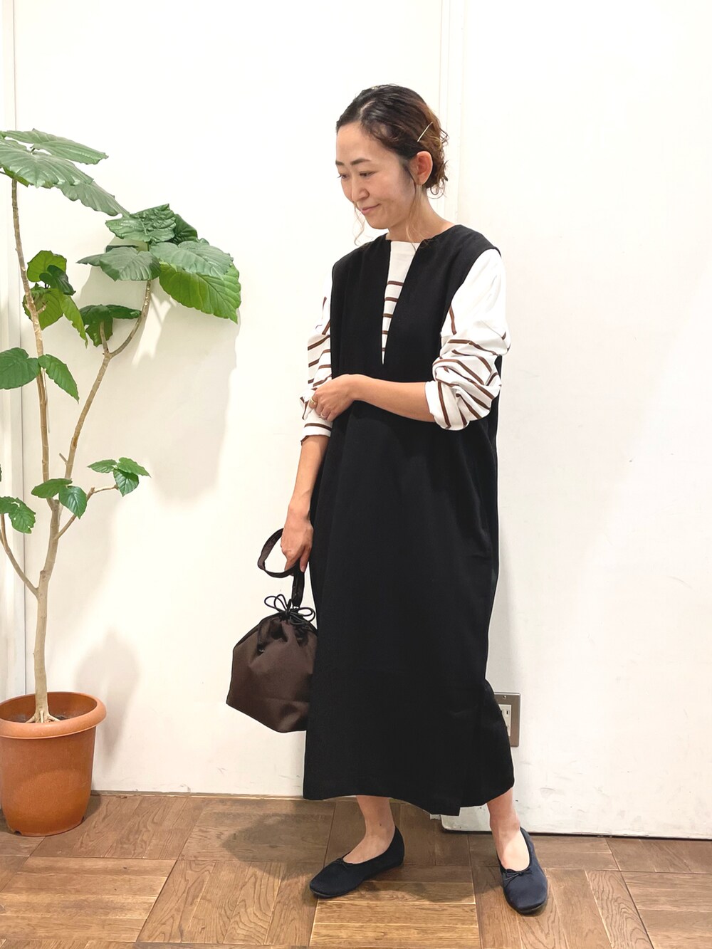 ブラック系のワンピース、ブラウン系のTシャツ/カットソー、ブラウン系のショルダーバッグを着用したレディースの秋コーディネートの2枚目の写真