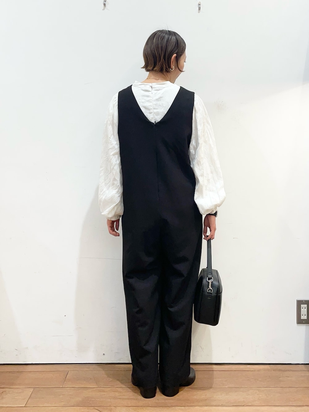 ブラック系のその他パンツ、ブラック系のショルダーバッグ、ブラック系のブーツを着用したレディースの冬コーディネートの5枚目の写真