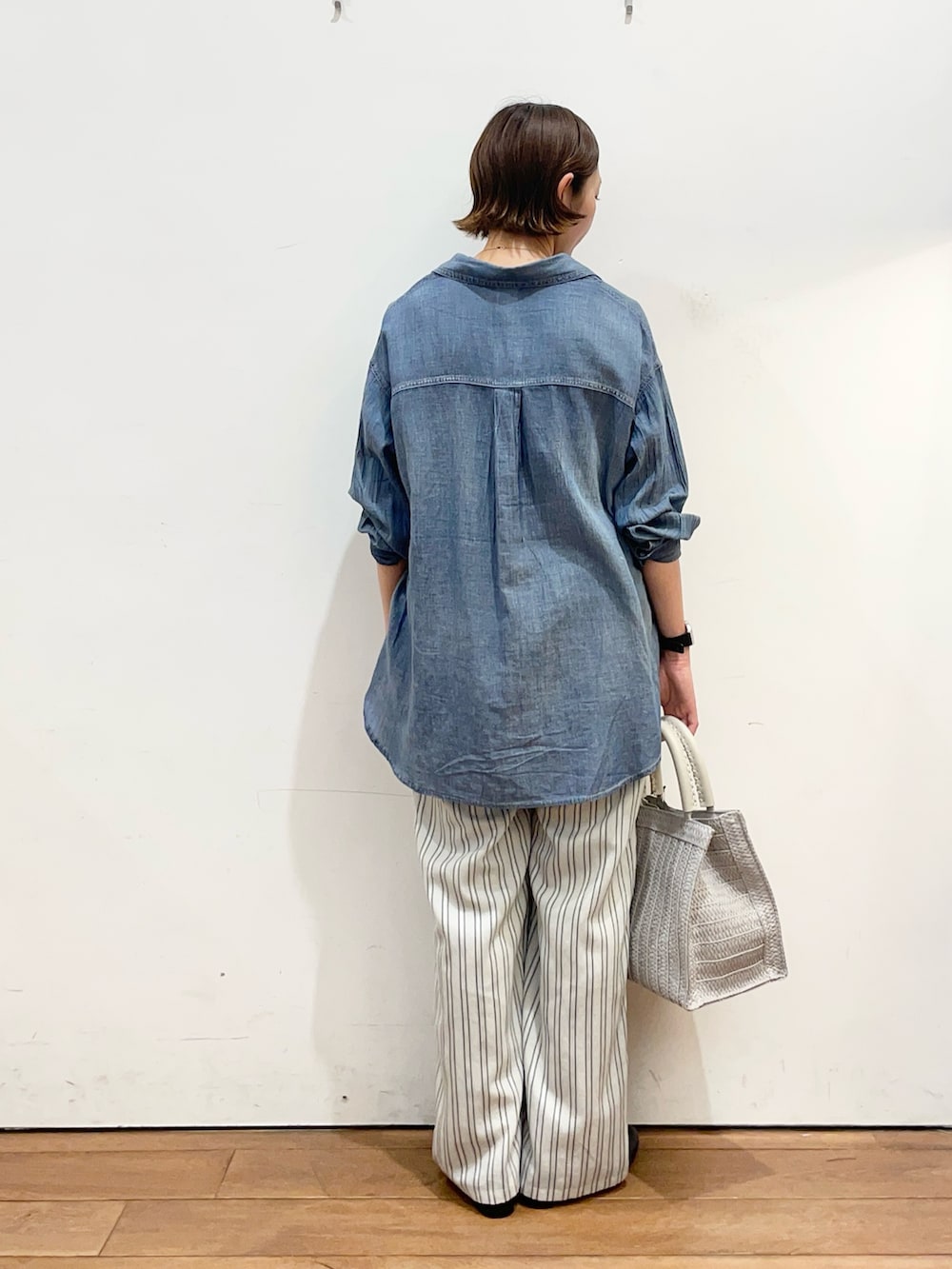 ブルー系のシャツ/ブラウス、ブラック系のTシャツ/カットソー、ブラック系のパンプスを着用したレディースの春コーディネートの4枚目の写真