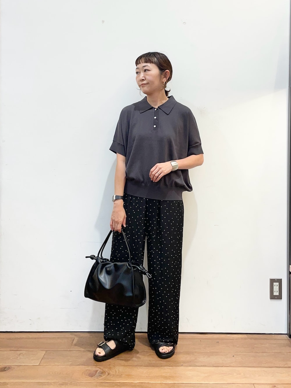 グレー系のニット/セーター、ブラック系のトートバッグ、ブラック系のサンダルを着用したレディースの夏コーディネートの3枚目の写真