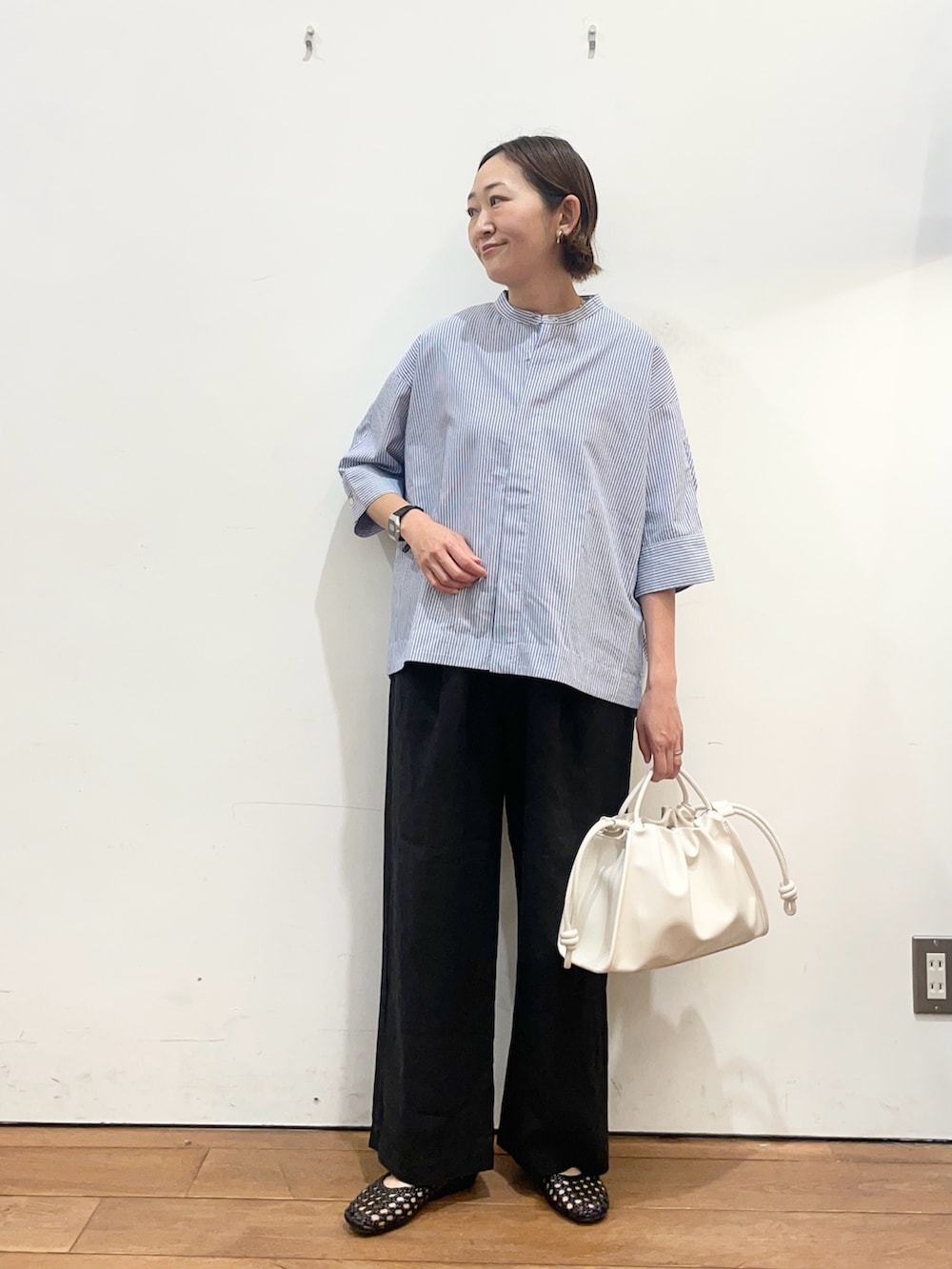 ブルー系のシャツ/ブラウス、ブラック系のその他パンツ、ホワイト系のトートバッグを着用したレディースの春コーディネートの2枚目の写真