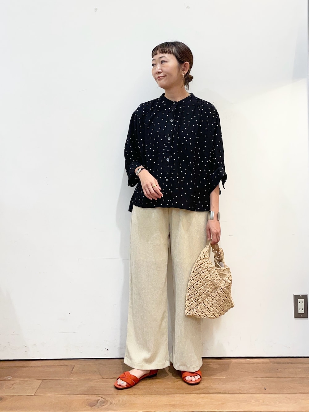 ブラック系のシャツ/ブラウス、ベージュ系のハンドバッグ、ベージュ系のその他パンツを着用したレディースの夏コーディネートの3枚目の写真