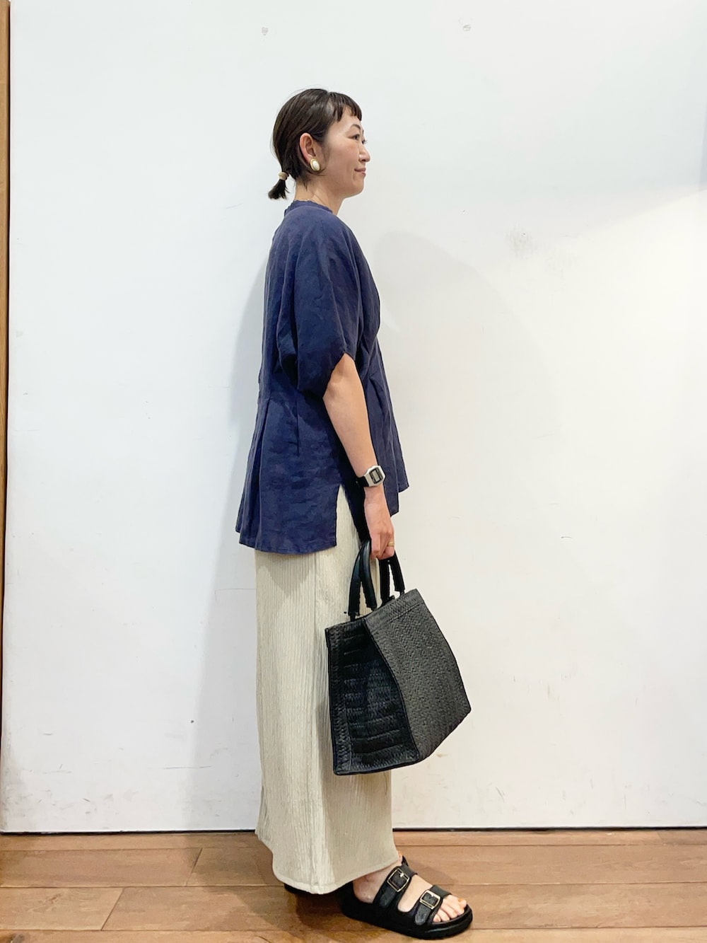 ブルー系のシャツ/ブラウス、ブラック系のハンドバッグ、ベージュ系のスカートを着用したレディースの夏コーディネートの3枚目の写真