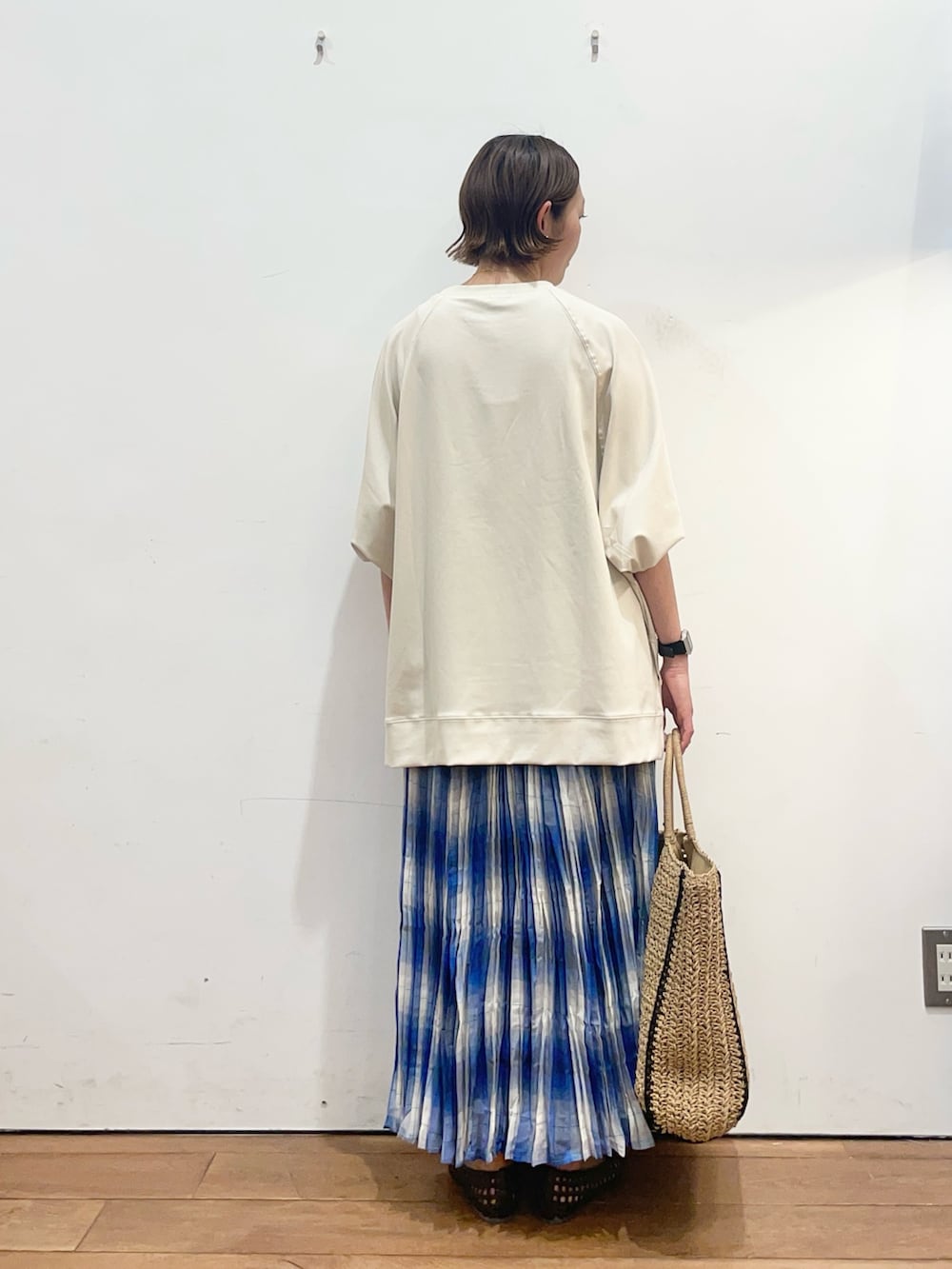 ベージュ系のTシャツ/カットソー、ブルー系のスカート、ブラウン系のサンダルを着用したレディースの春コーディネートの4枚目の写真