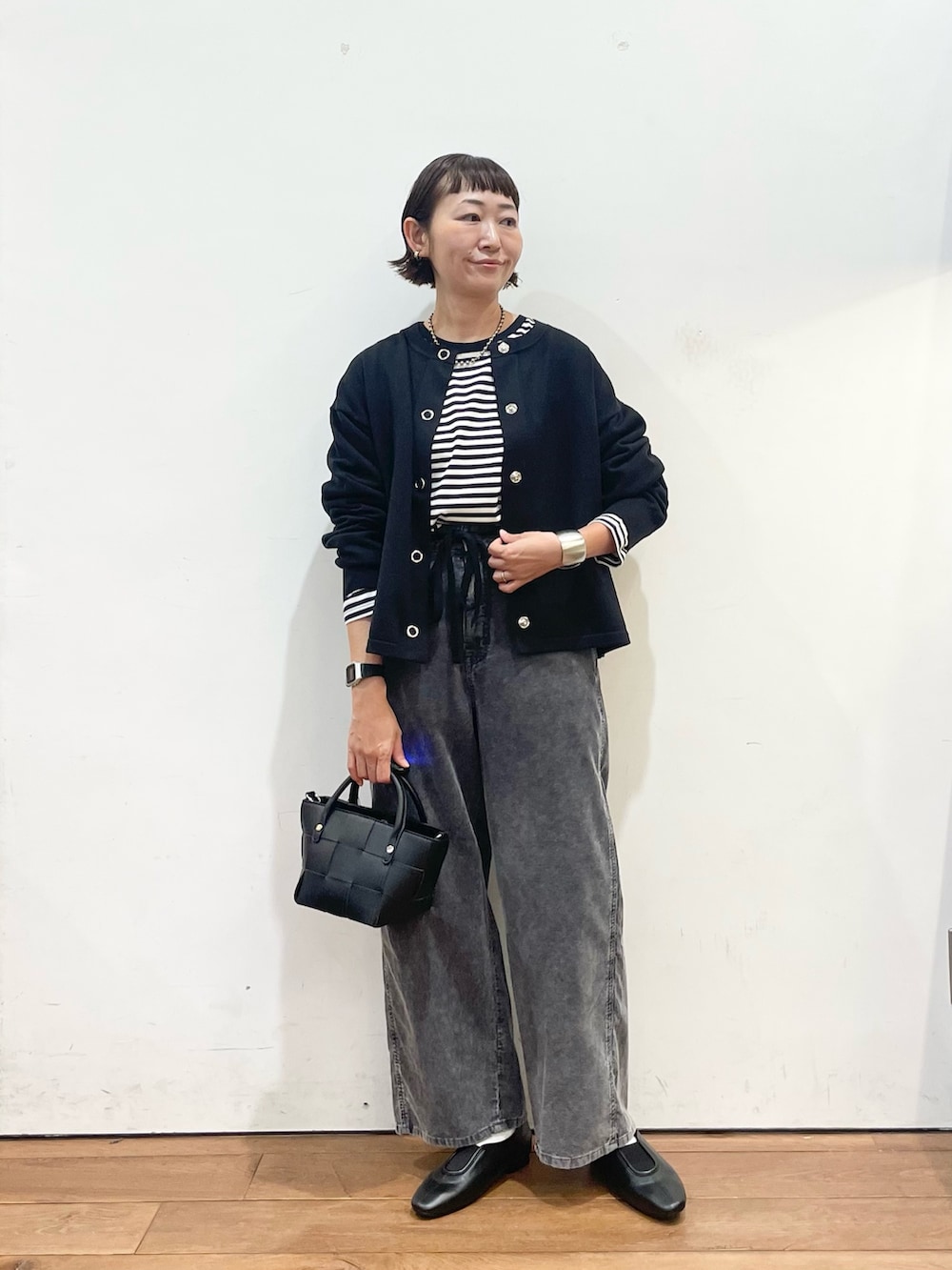 ブラック系のカーディガン/ボレロ、ホワイト系のTシャツ/カットソー、ブラック系のスリッポンを着用したレディースの秋コーディネートの2枚目の写真