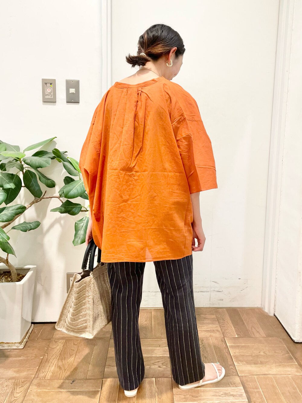 オレンジ系のシャツ/ブラウス、グレー系のその他パンツ、ホワイト系のサンダルを着用したレディースの夏コーディネートの5枚目の写真