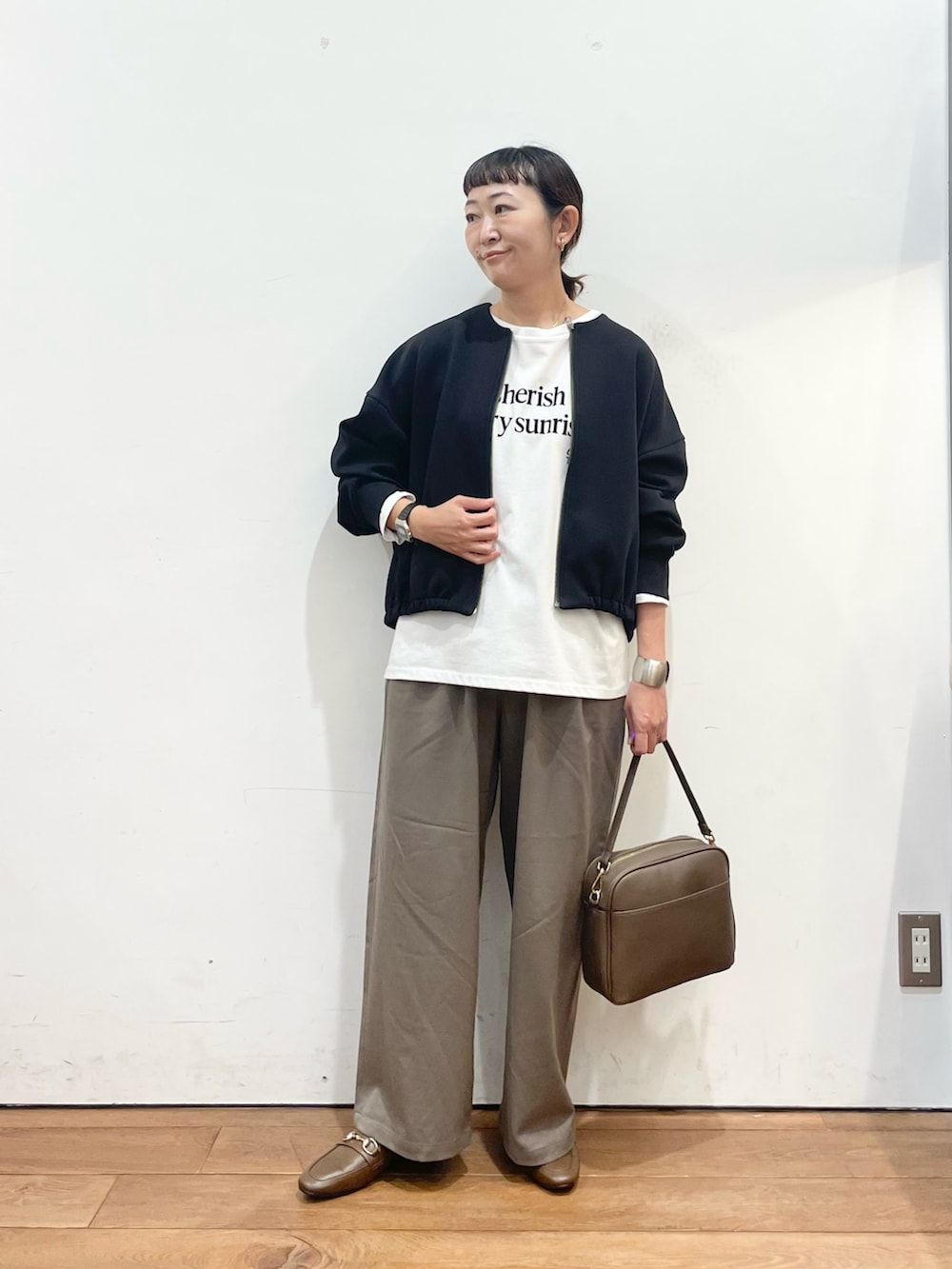 ブラック系のカーディガン/ボレロ、ホワイト系のTシャツ/カットソー、ベージュ系のその他パンツを着用したレディースの秋コーディネートの2枚目の写真