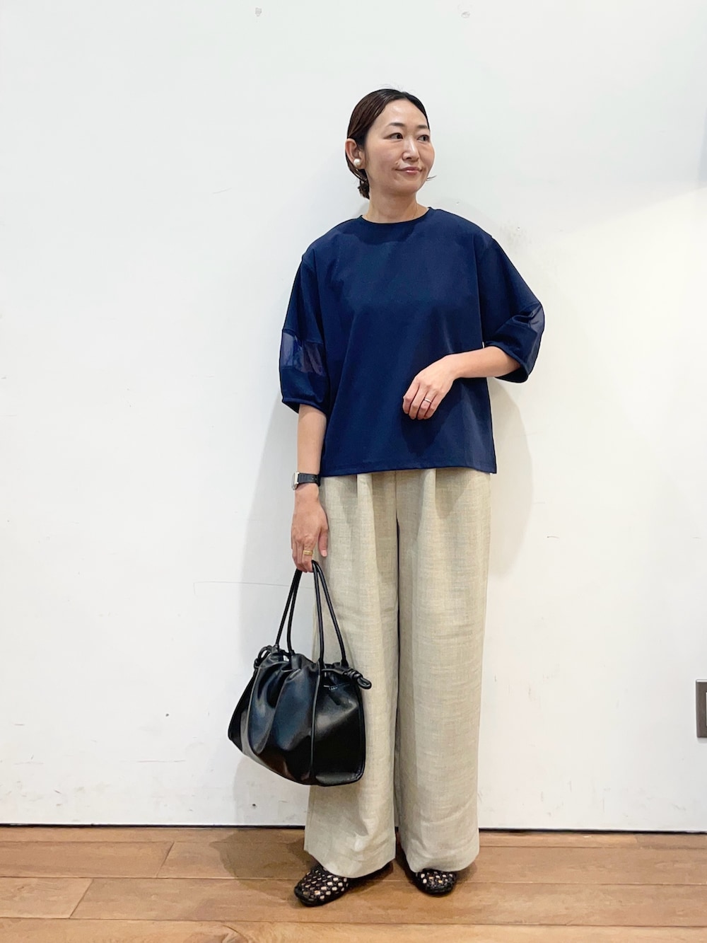 ブルー系のTシャツ/カットソー、ベージュ系のその他パンツ、ブラック系のサンダルを着用したレディースの春コーディネートの2枚目の写真