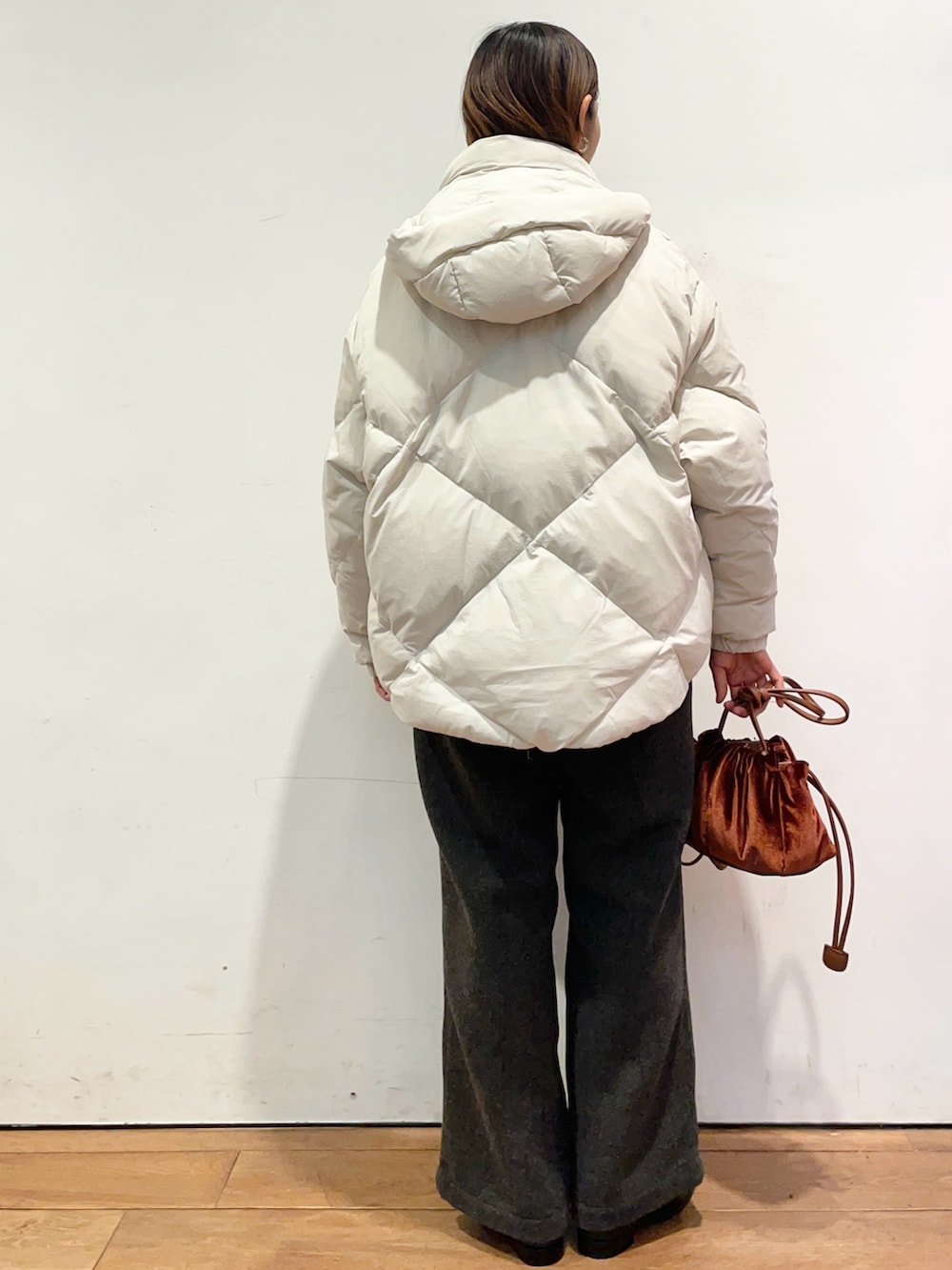 ホワイト系のダウンジャケット/コート、ブラウン系のニット/セーター、ブラック系のブーツを着用したレディースの秋コーディネートの4枚目の写真