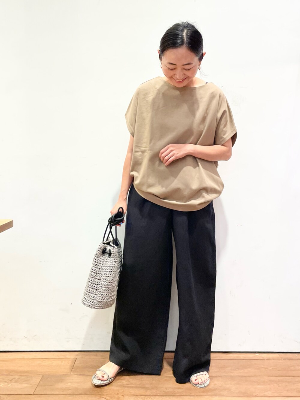 ベージュ系のTシャツ/カットソー、ブラック系のその他パンツ、グレー系のショルダーバッグを着用したレディースの夏コーディネートの2枚目の写真