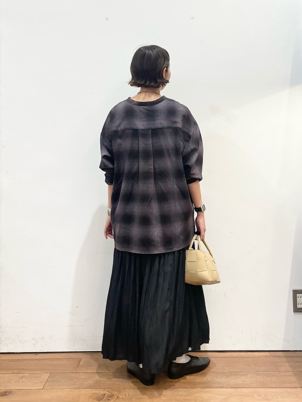 ベージュ系のハンドバッグ、グレー系のシャツ/ブラウス、ブラック系のスカートを着用したレディースの秋コーディネートの5枚目の写真