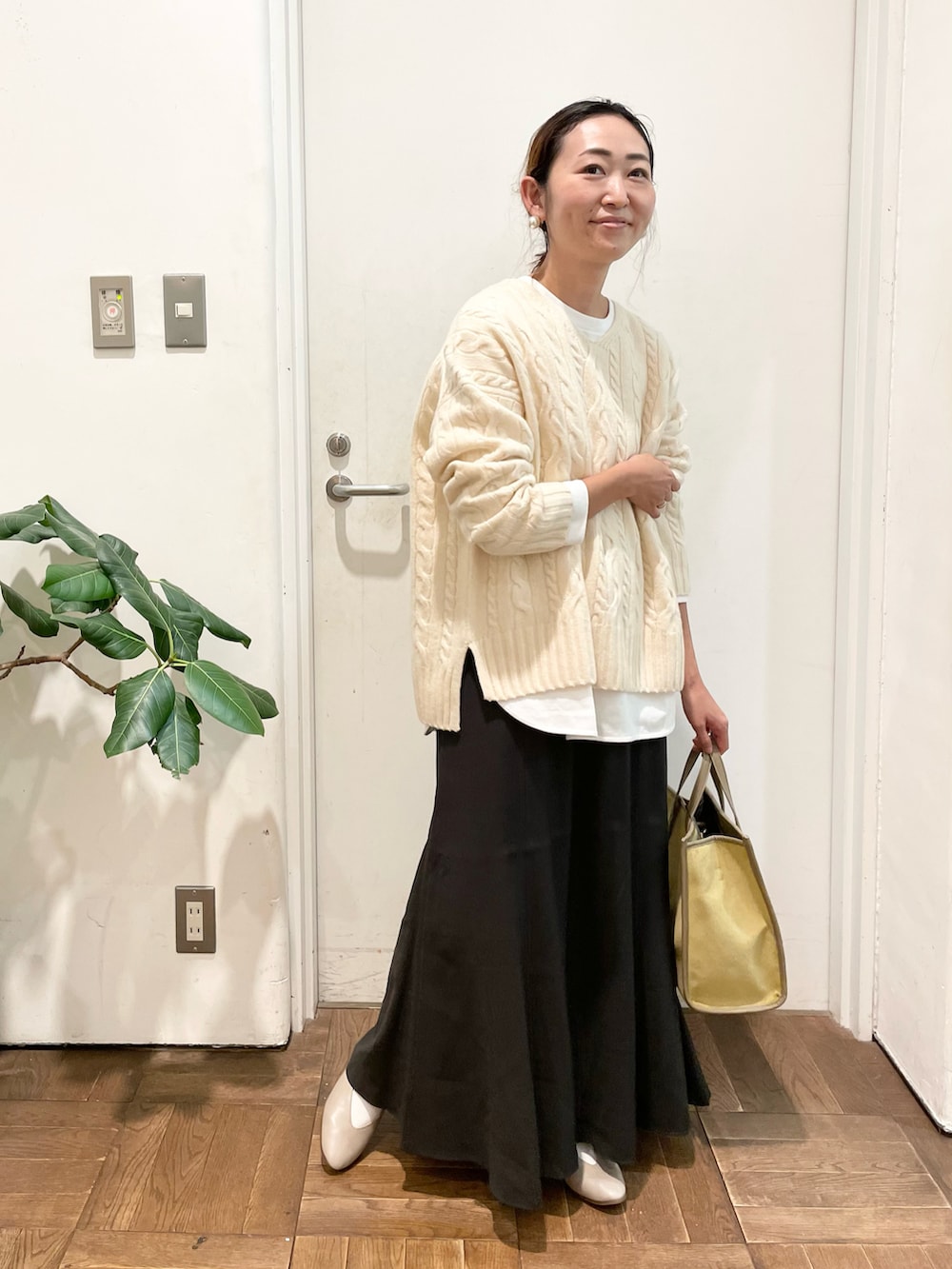 ホワイト系のニット/セーター、ホワイト系のTシャツ/カットソー、グレー系のスカートを着用したレディースの秋コーディネートの2枚目の写真