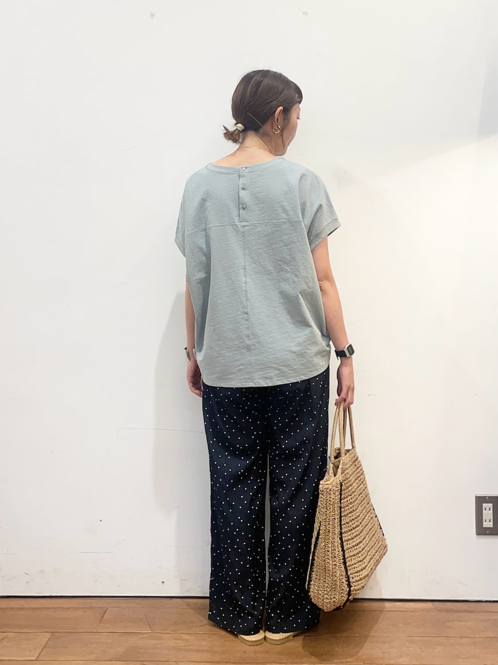 グリーン系のTシャツ/カットソー、ベージュ系のトートバッグ、ホワイト系のサンダルを着用したレディースの夏コーディネートの4枚目の写真