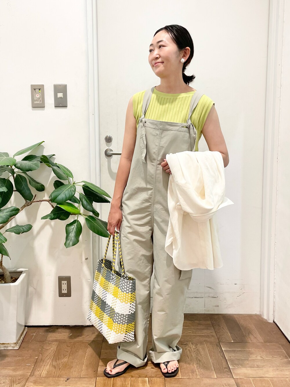 ベージュ系のサロペット/オーバーオール、イエロー系のTシャツ/カットソー、ホワイト系のシャツ/ブラウスを着用したレディースの夏コーディネートの3枚目の写真