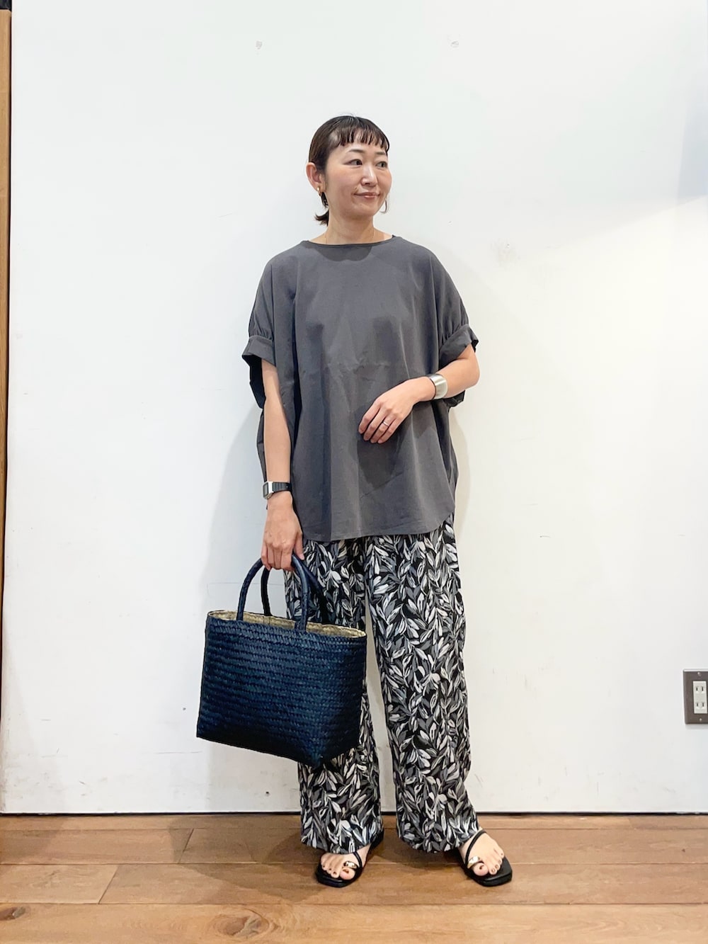 グレー系のTシャツ/カットソー、ブルー系のトートバッグ、ブラック系のその他パンツを着用したレディースの夏コーディネートの2枚目の写真