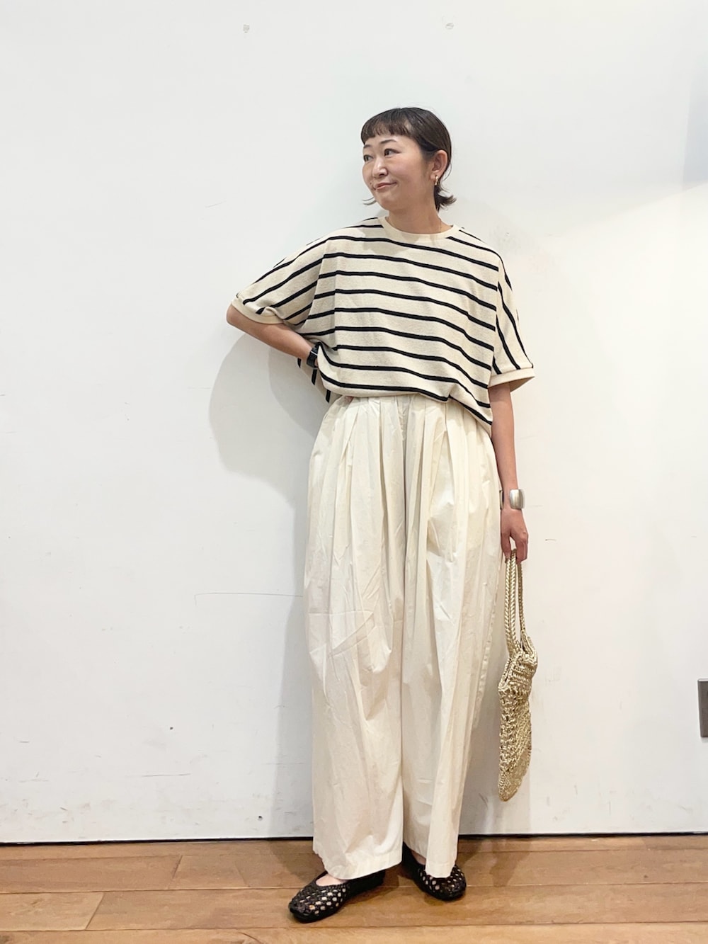 ホワイト系のTシャツ/カットソー、ホワイト系のその他パンツ、ゴールド系のトートバッグを着用したレディースの夏コーディネートの3枚目の写真