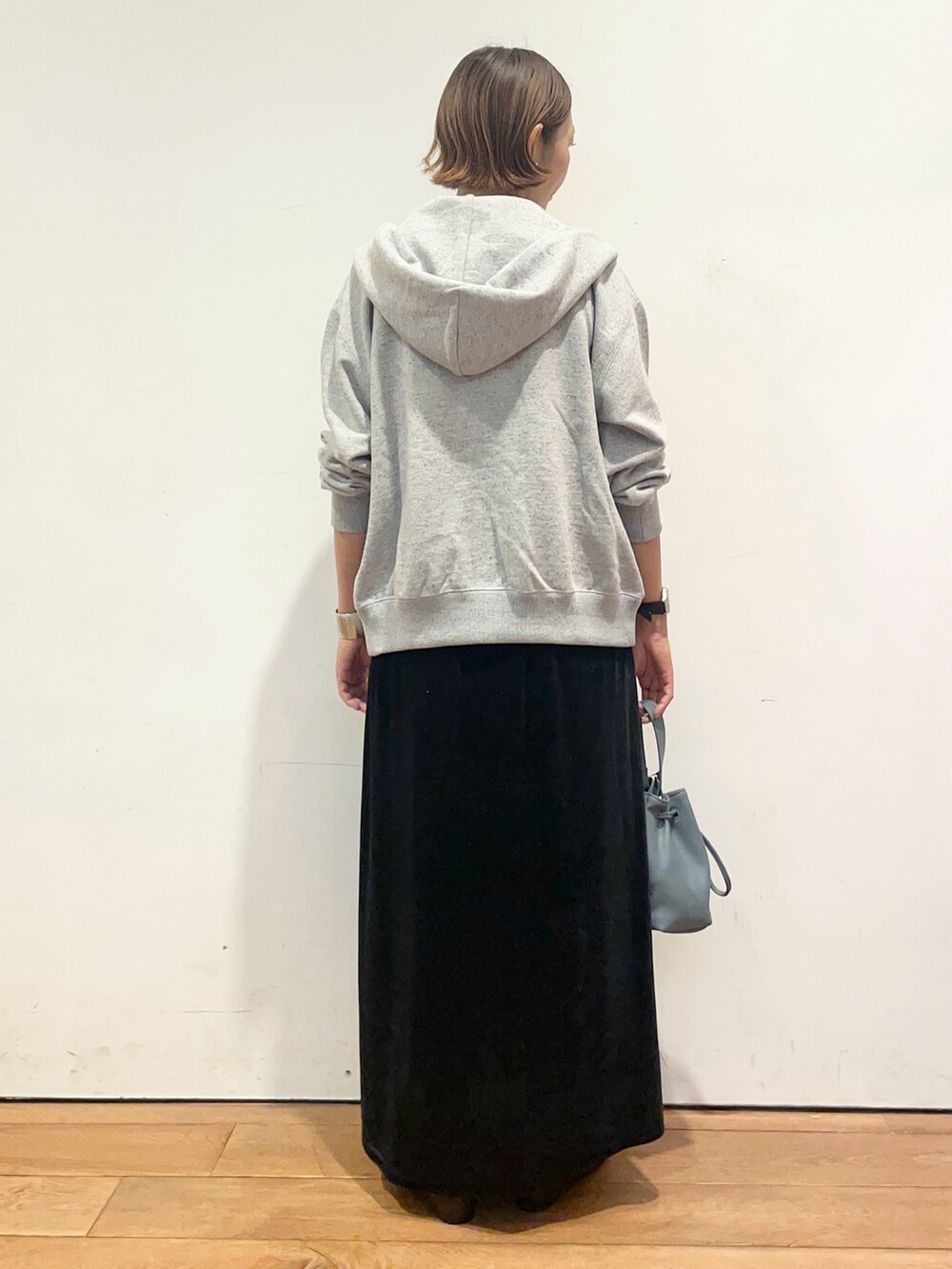 ブルー系のショルダーバッグ、ブラウン系のパンプス、ブラック系のワンピースを着用したレディースの秋コーディネートの5枚目の写真