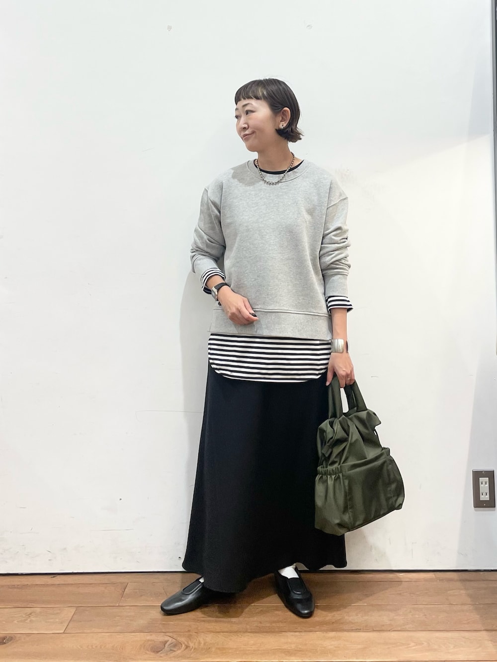 グレー系のスウェット、ホワイト系のTシャツ/カットソー、ブラック系のスリッポンを着用したレディースの秋コーディネートの2枚目の写真